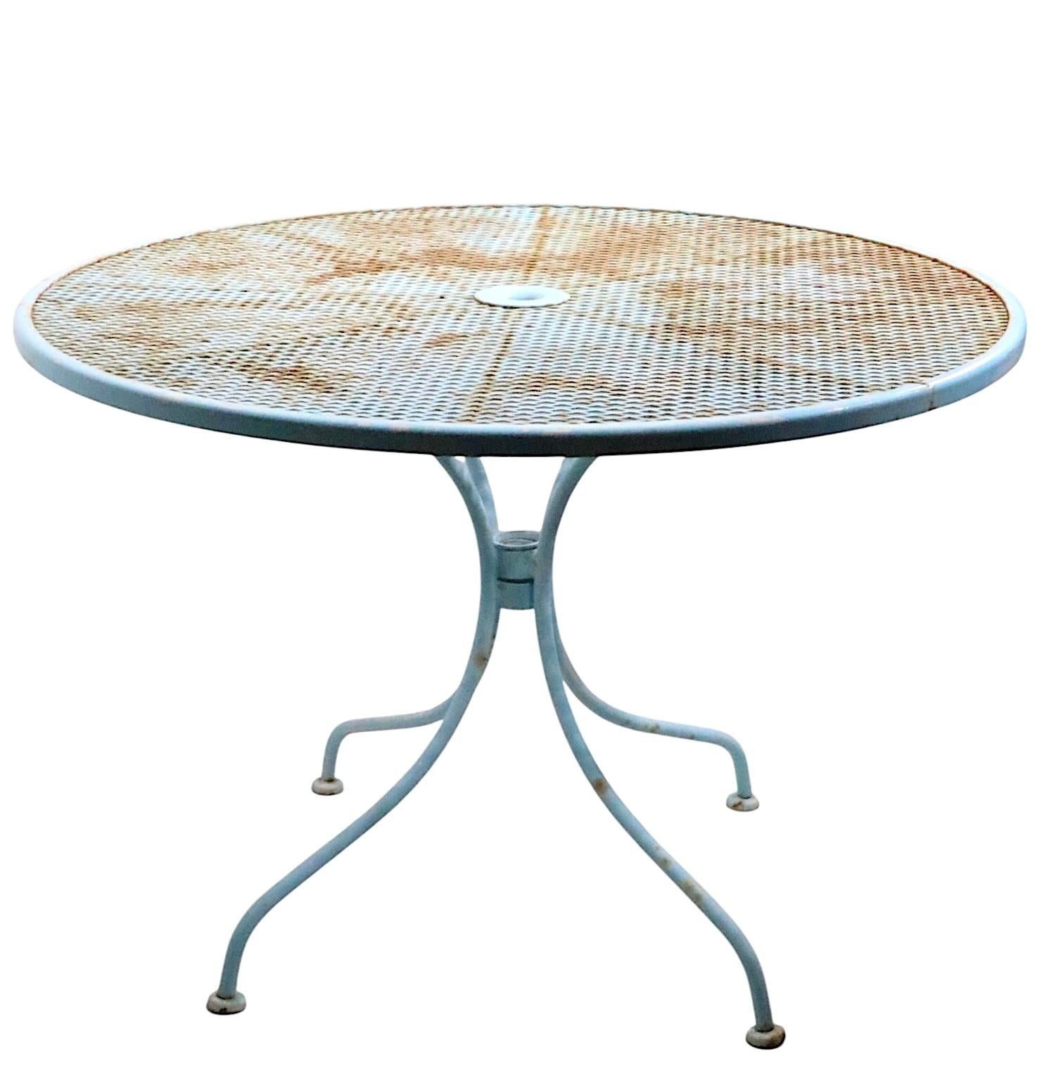 Stylish Mid Century wrought iron and metal mesh cafe, dining table by the Woodard Furniture Company, circa 1950/60's. The table is in very good, clean and ready to use condition, currently in later, but not new, powder blue paint finish, finish