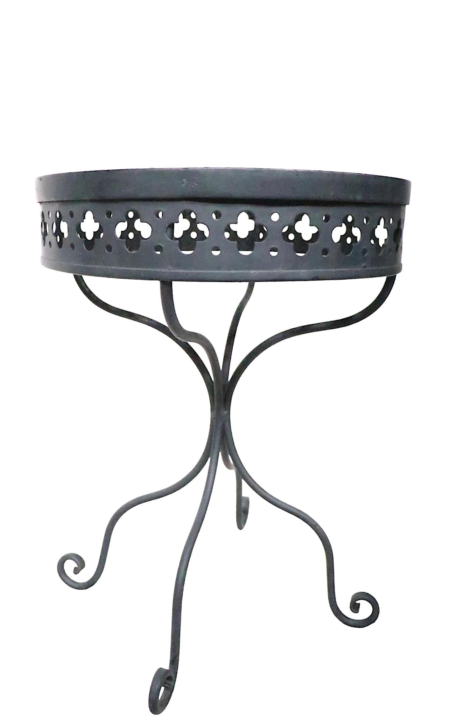 Rare Taj Mahal pattern garden table by Salterini. The table features a circular metal mesh top, with decorative quatrefoil pattern skirt, on a wrought iron pedestal base. This example is in very good condition, free of damage or repairs, it is