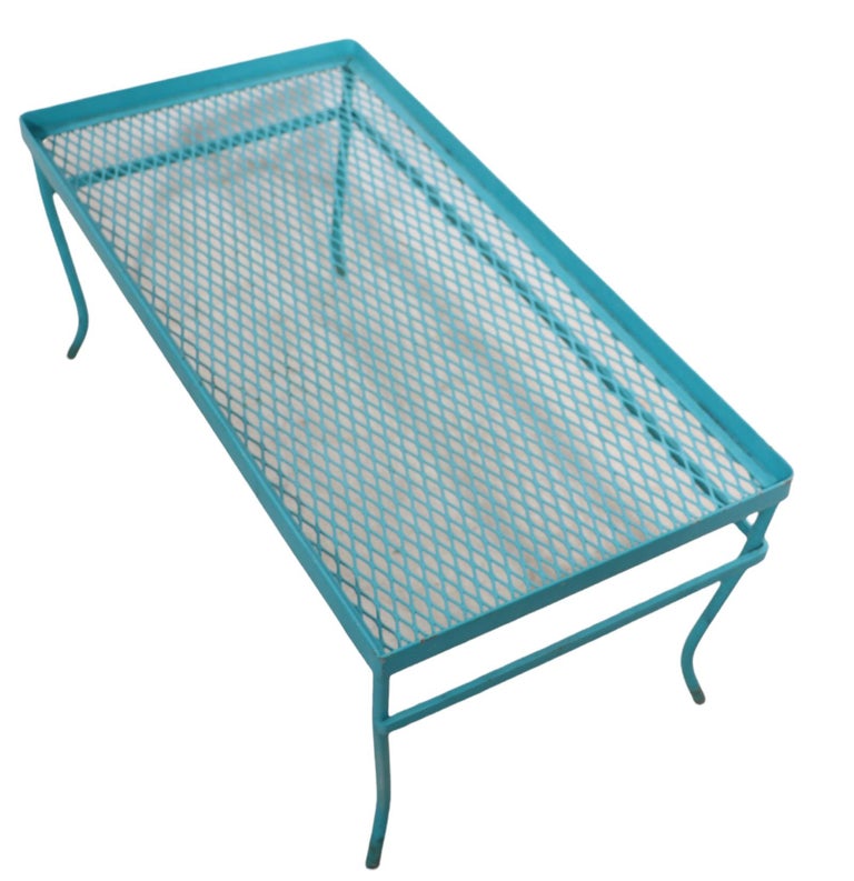 Unusual wrought iron and metal mesh garden, patio, poolside table attributed to Woodard Furniture Company. Usual as a coffee table, occasional table or perhaps a plant stand, we believe this example may have originally been part of a nesting set, as