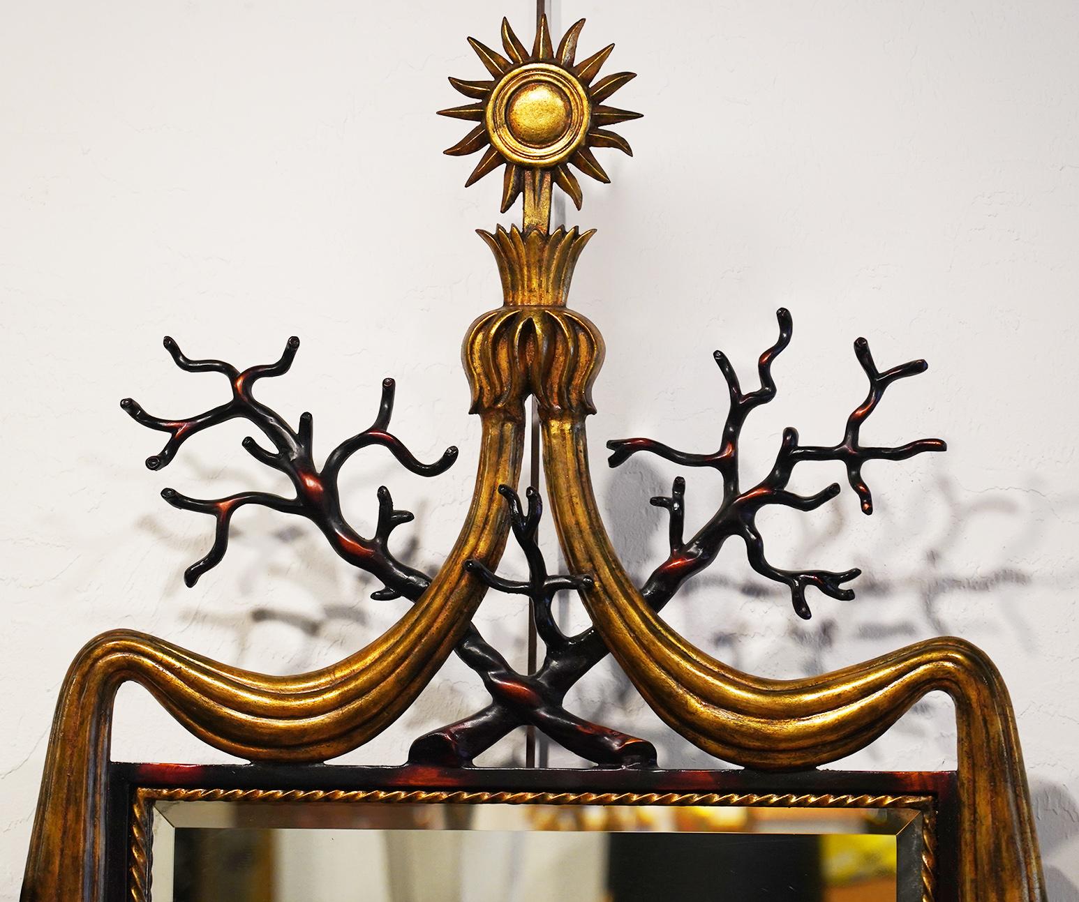 Iron mirror with painted decoration in the manner of Gilbert Poillerat. Gilt highlights with branch design and sunburst on top.