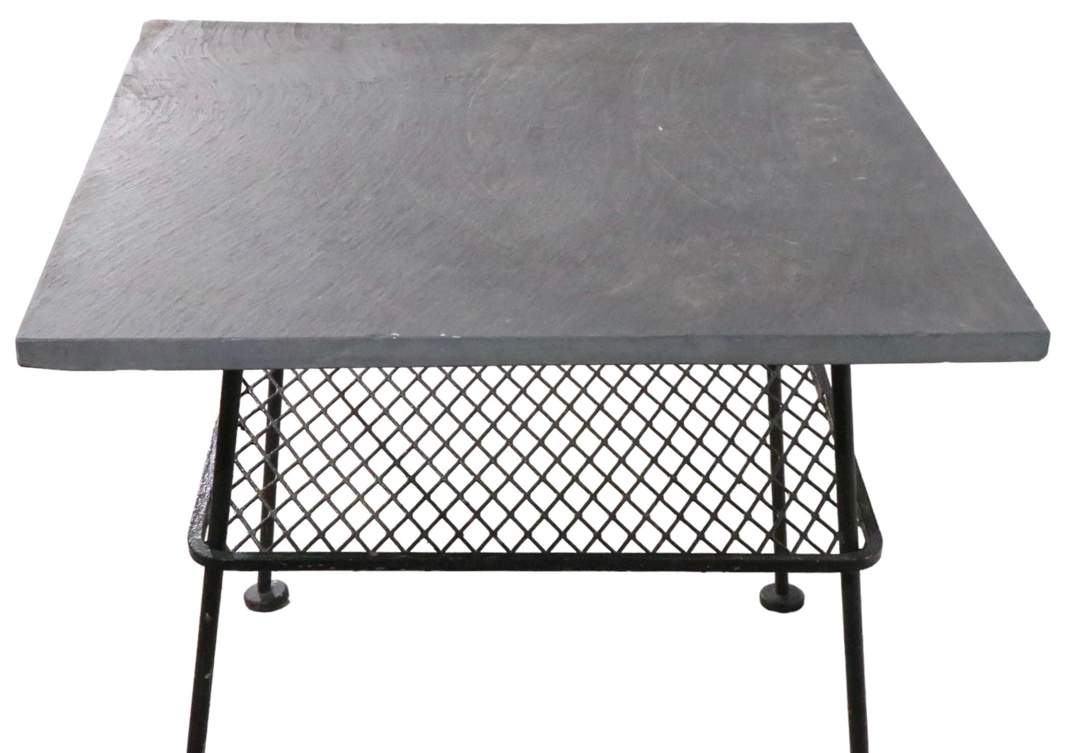 Great architectural end, side table with a thick slate top on wrought iron base. The table features two shelves top 22 H x Lower 14.5 H inches - the lower shelf is of metal mesh. Clean, ready to use condition, showing only light cosmetic wear,