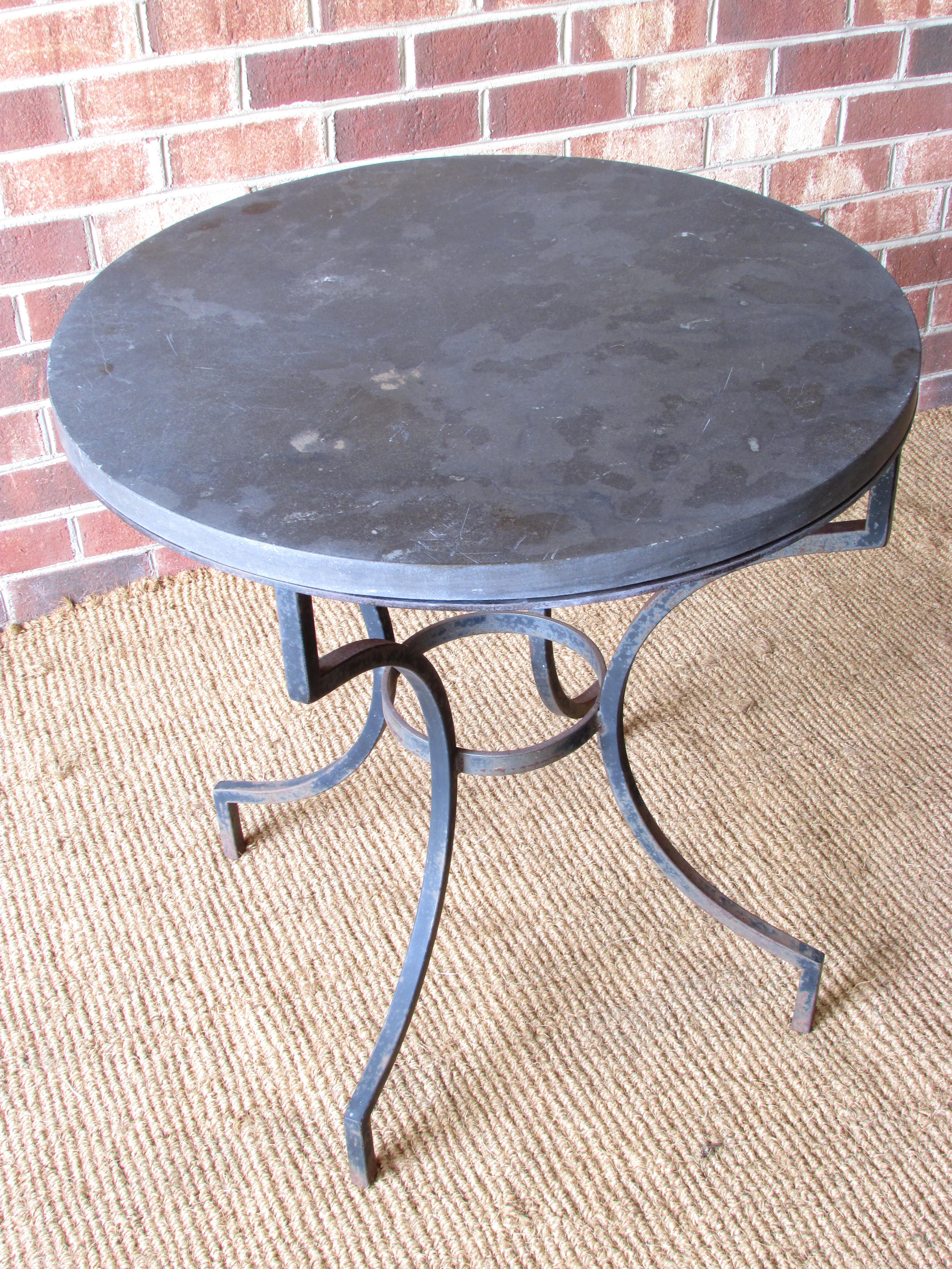 Lamp table with wrought iron base and round slate top.
