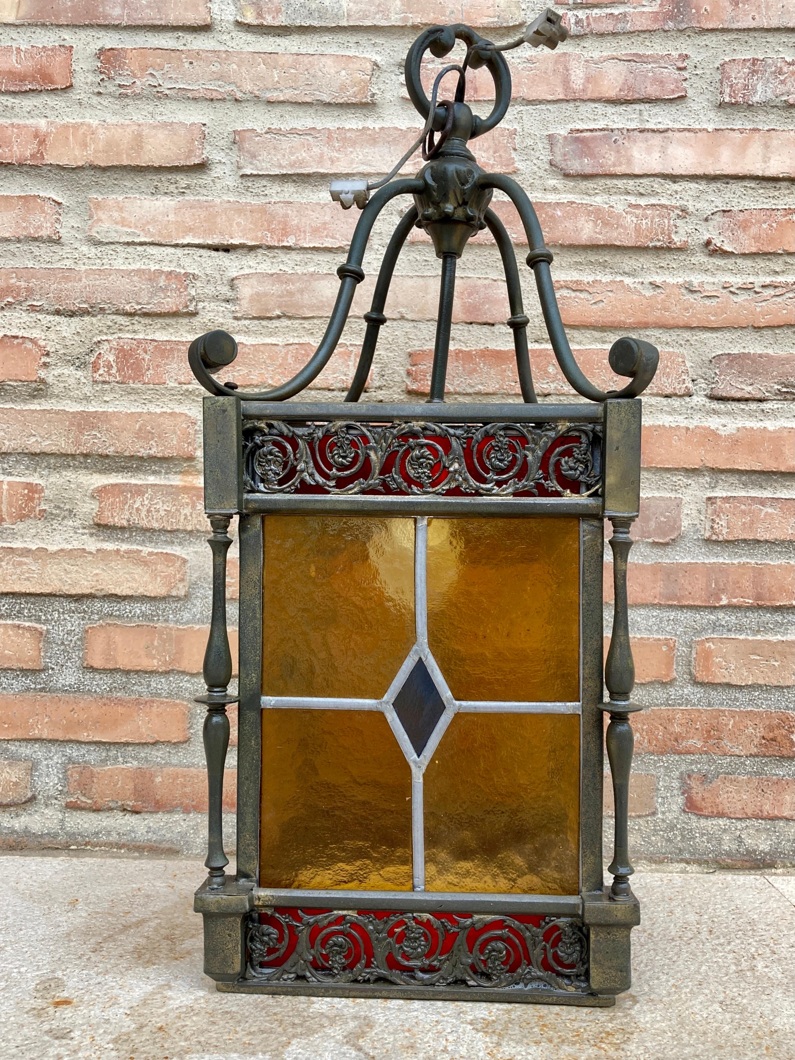 Antique wrought iron and stained glass ceiling lantern lamp

Old outdoor lantern lamp with wrought iron ceiling and colored glass.

Wrought iron lantern with good ornamental work, it serves both for interior and exterior. Very robust, good