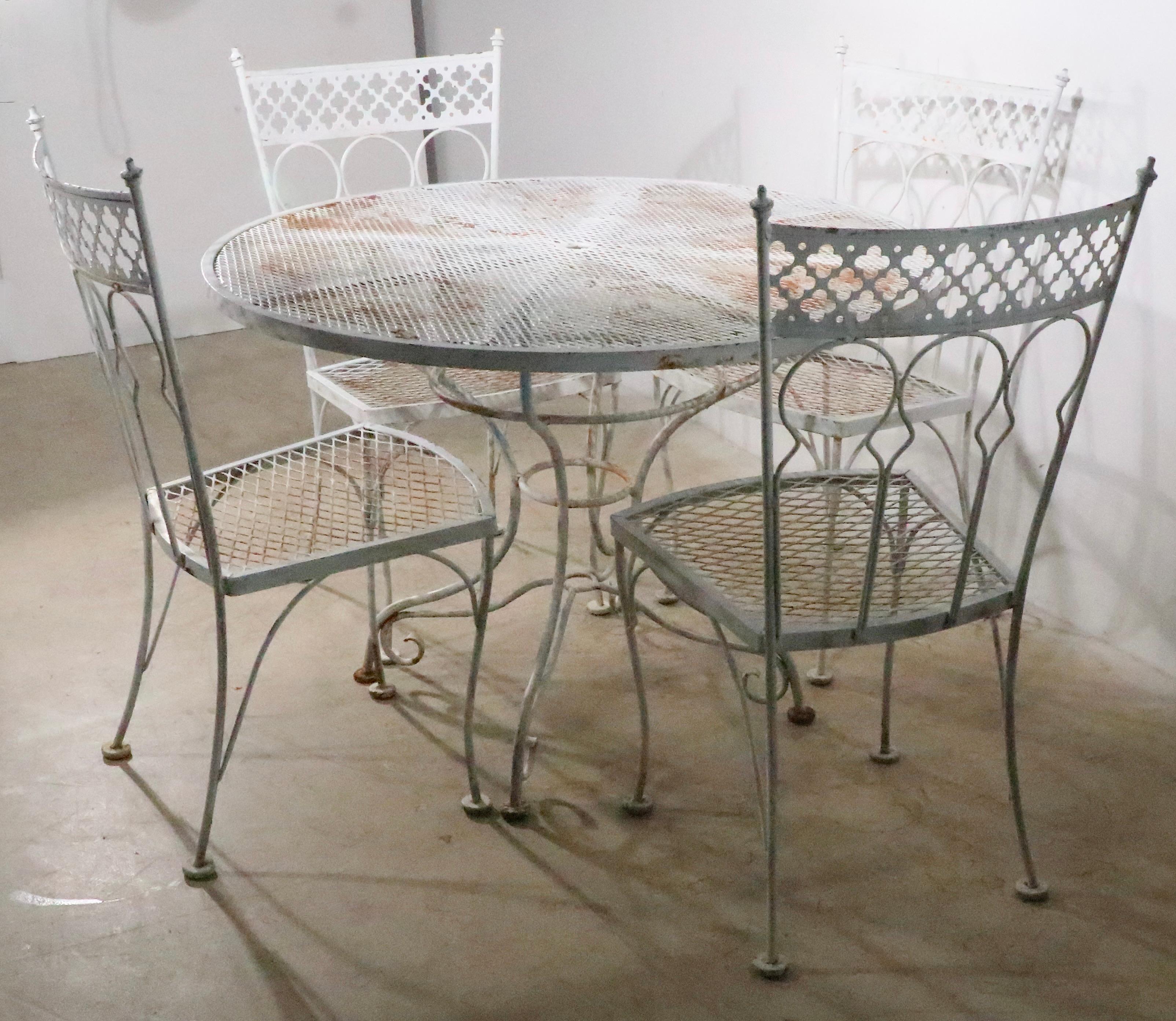 Rare garden, patio, poolside, sunroom dining set in the Taj Mahal pattern, by Salterini. The set includes the round dining table and its four original dining chairs. All pieces are in good, original estate condition, showing only cosmetic wear to