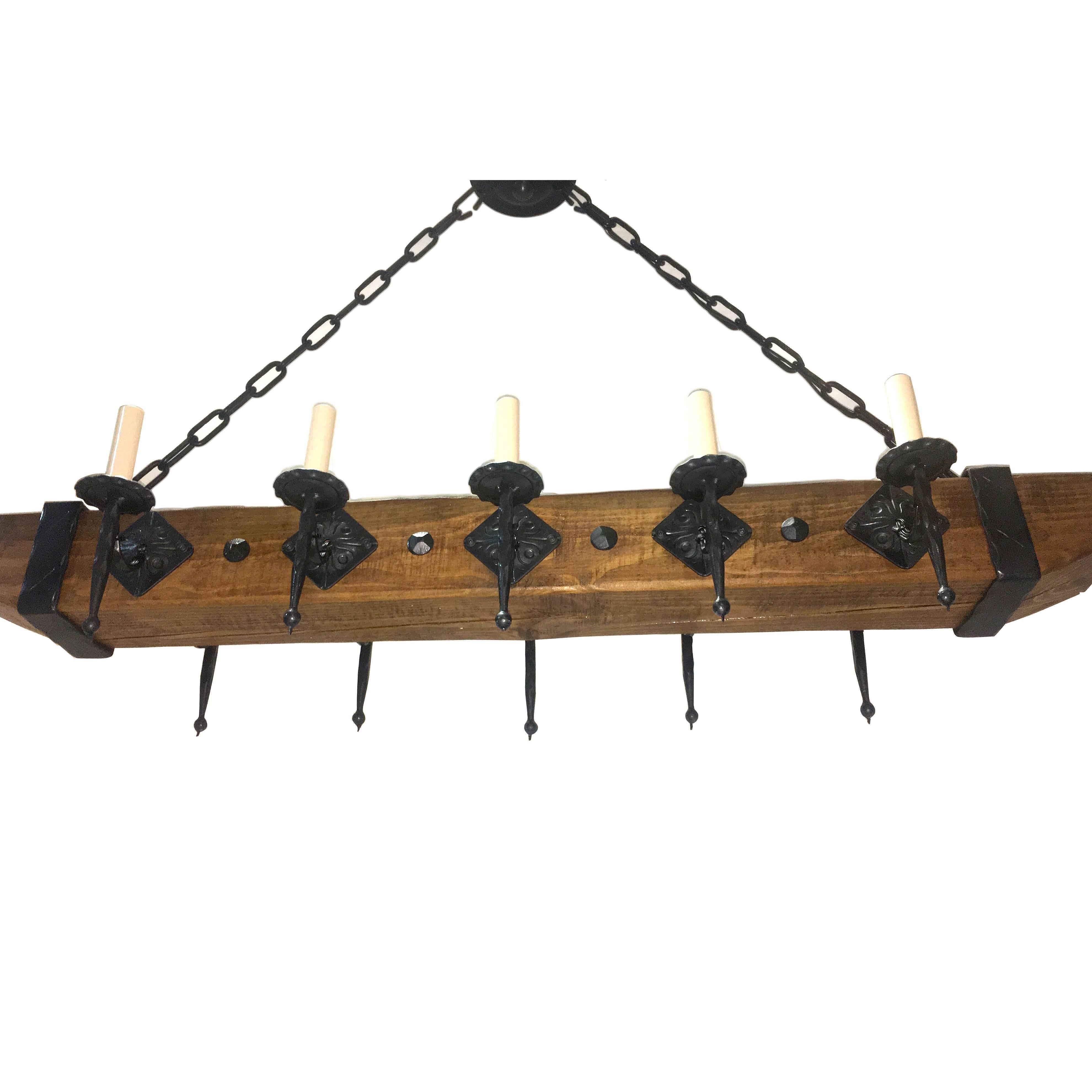 A circa 1940's French wrought iron chandelier with wooden body.

Measurements:
Drop: 30.5