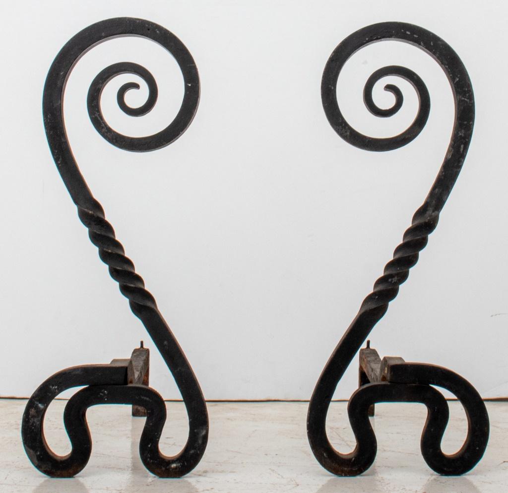 Wrought iron andirons, a pair, in the arts and crafts taste, possibly American, early 20th century or later, with twisted and scrolling elements. 24