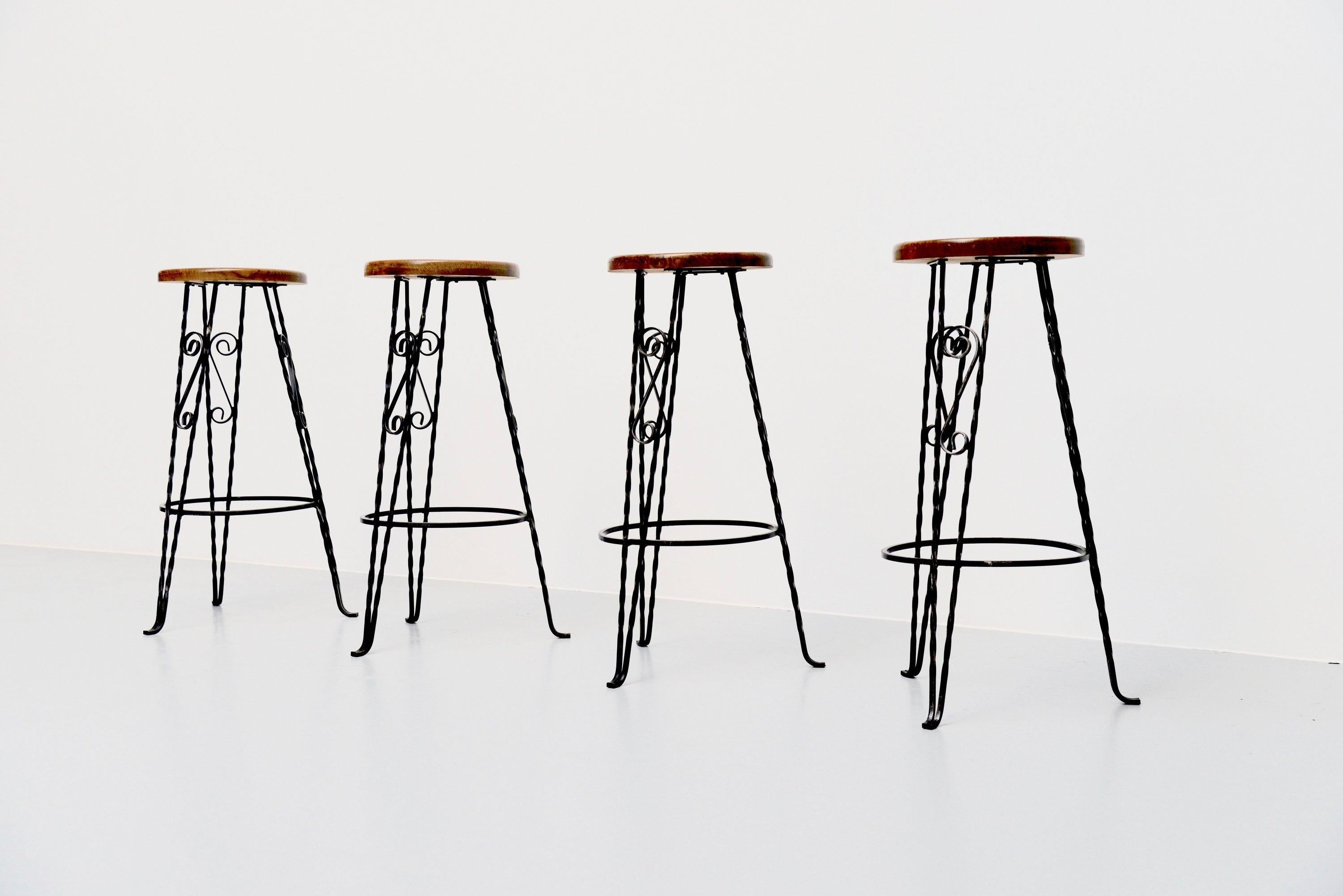 Set of 4 wrought iron bar stools made by unknown designer or manufacturer in France, 1960s. Stools are in the style of Guillerme and Chambron and Mathieu Mategot. The stools have a wrought iron sculptural shaped frame and an ash wooden seat. Very