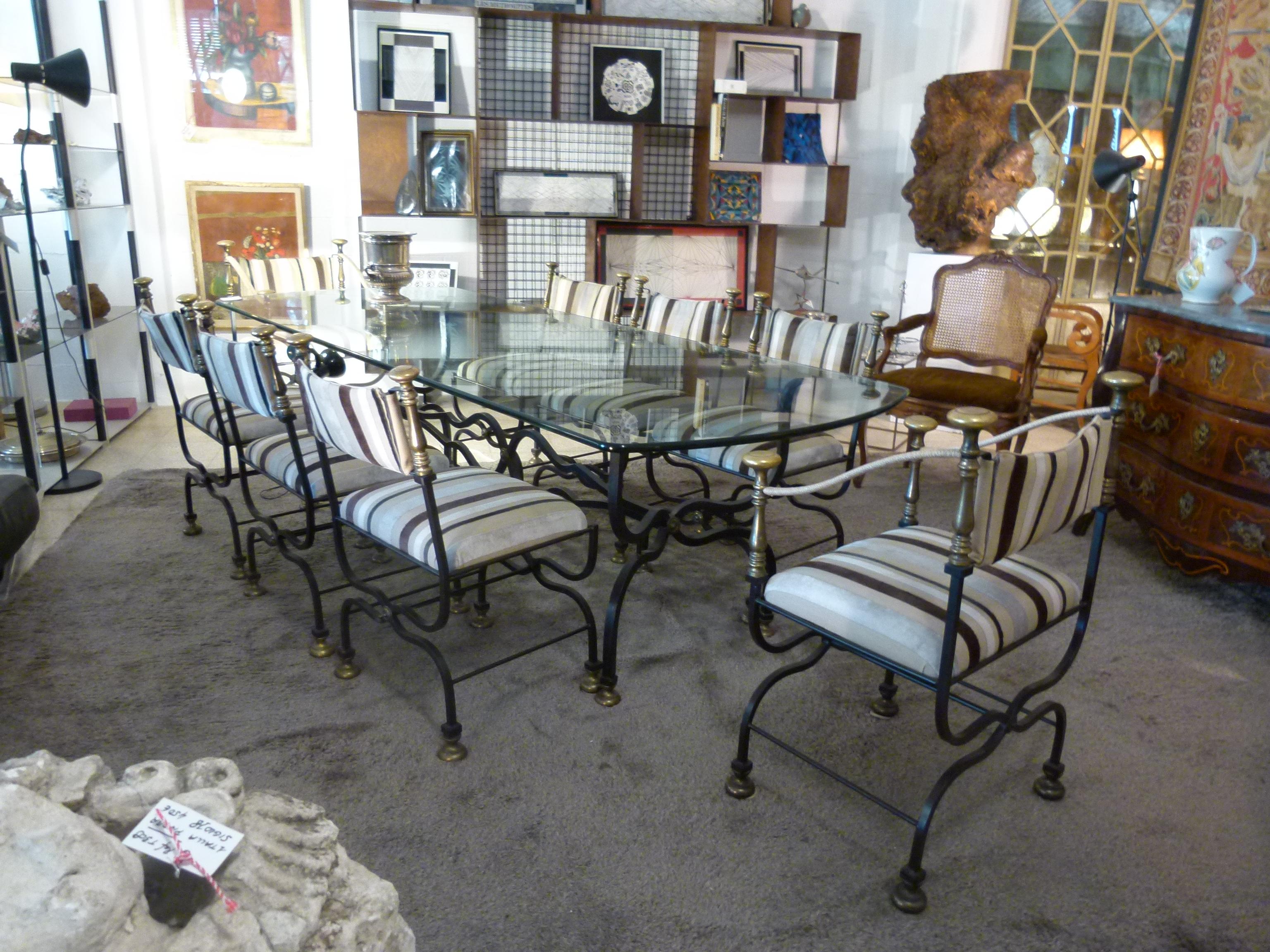 Large  glass top dining table with rounded corners and wrought iron base.  4  iron chairs and 2 iron armchairs  complete the whole dining set.

Measurements:
Table: 100 x 250 x 75cm. Glass thickness 2 cm
Armchair: 60 x 47 x 91 cm
Chair: 51 x 56 x 88