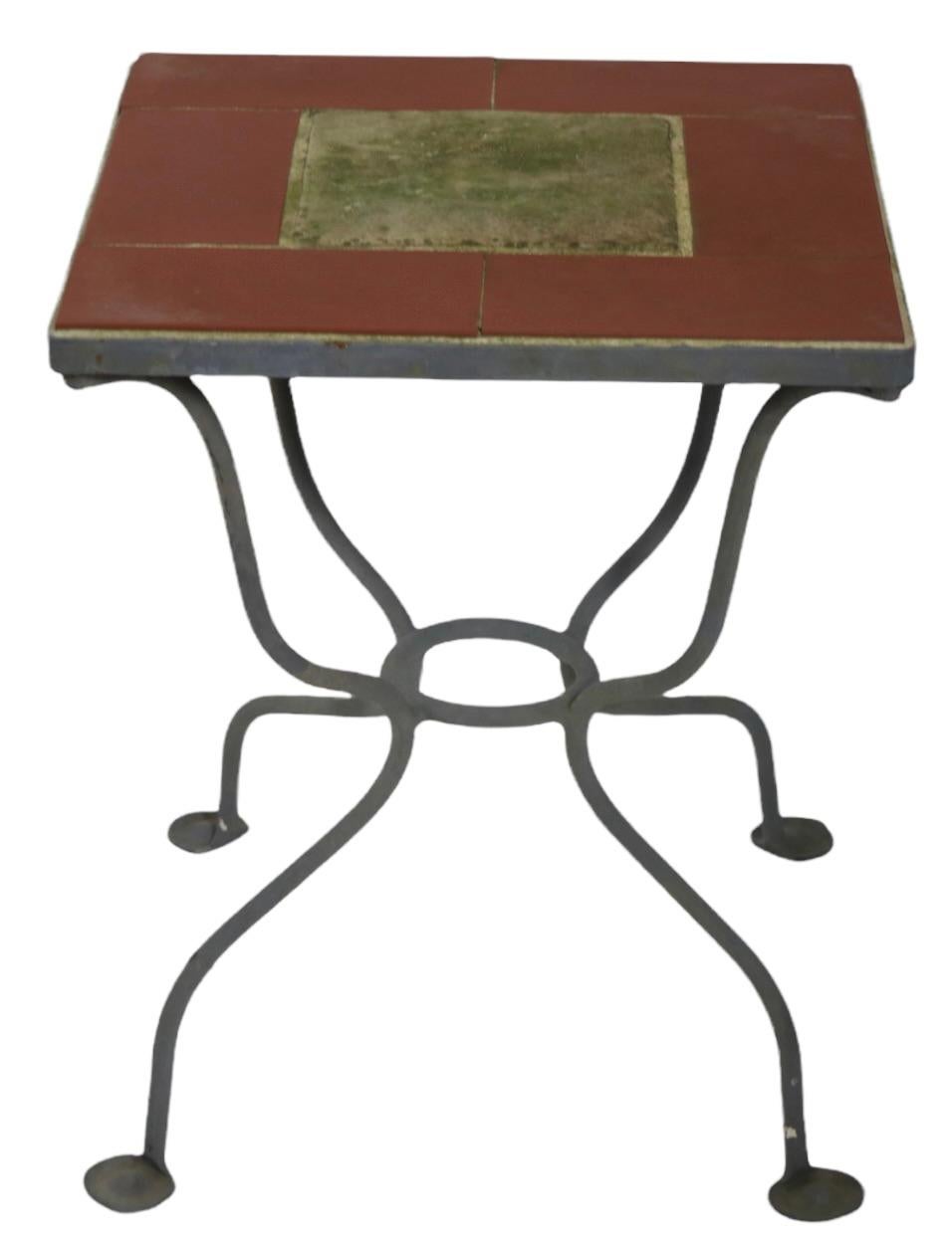 Wonderful wrought iron and ceramic tile table, marked Salterini. The table is in very good condition, free of damage, clean and ready to use. 
Please view our extensive collection of garden and patio furniture listed at Barbarella Home, on 1st Dibs.