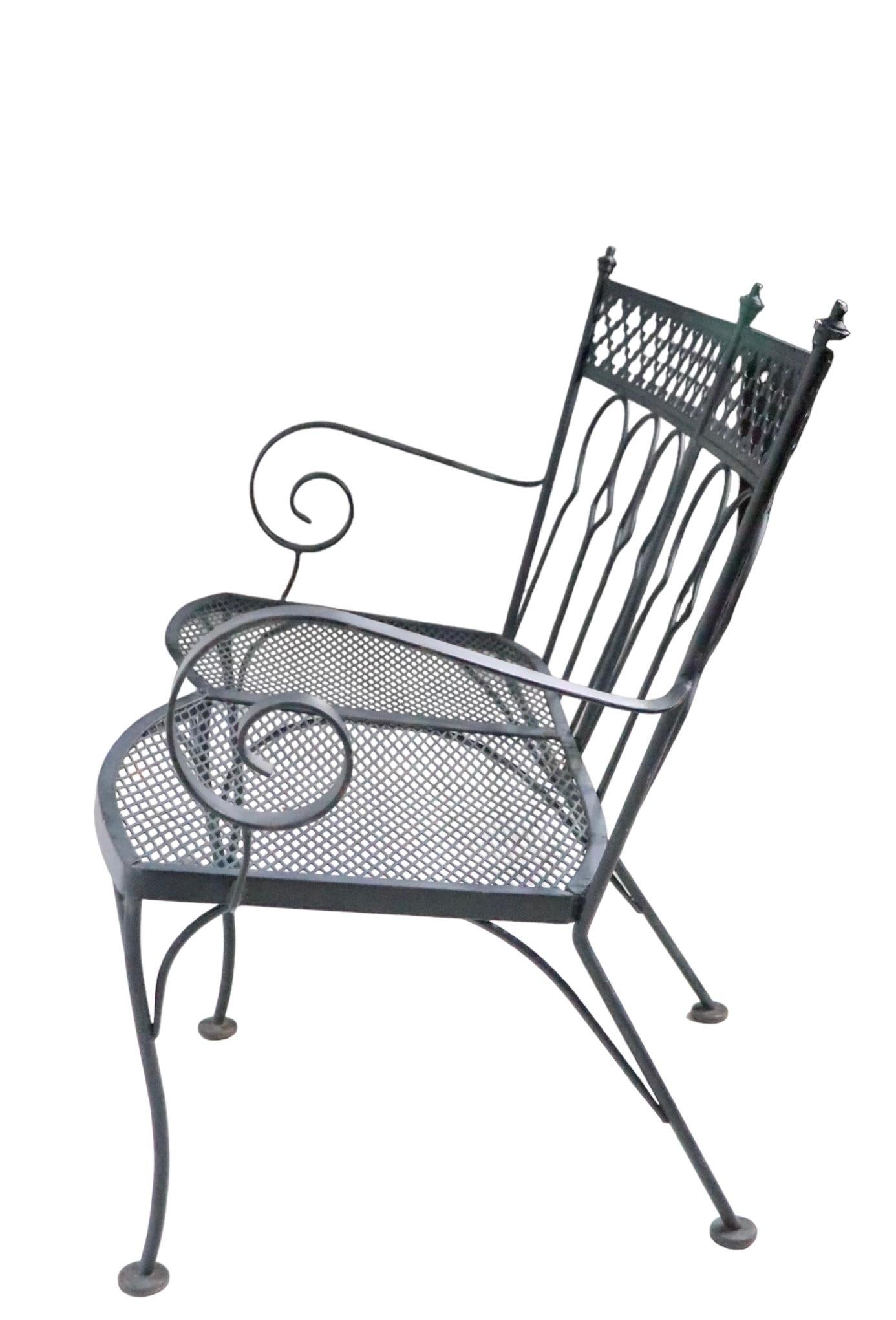 Rare Salterini bench, in the Taj Mahal pattern. The bench features a wrought iron frame, wrought iron back supports, decorative cast metal finials, and a metal mesh seat.
 This pattern is not often seen on the market, and the bench is even more