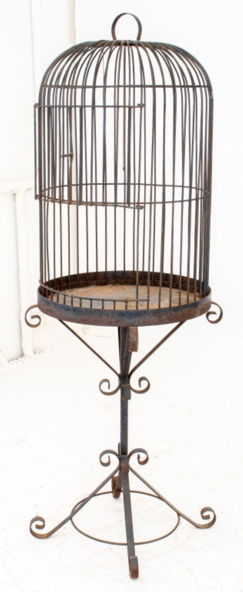 Wrought iron birdcage on stand, with adjustable door, unmarked. 68