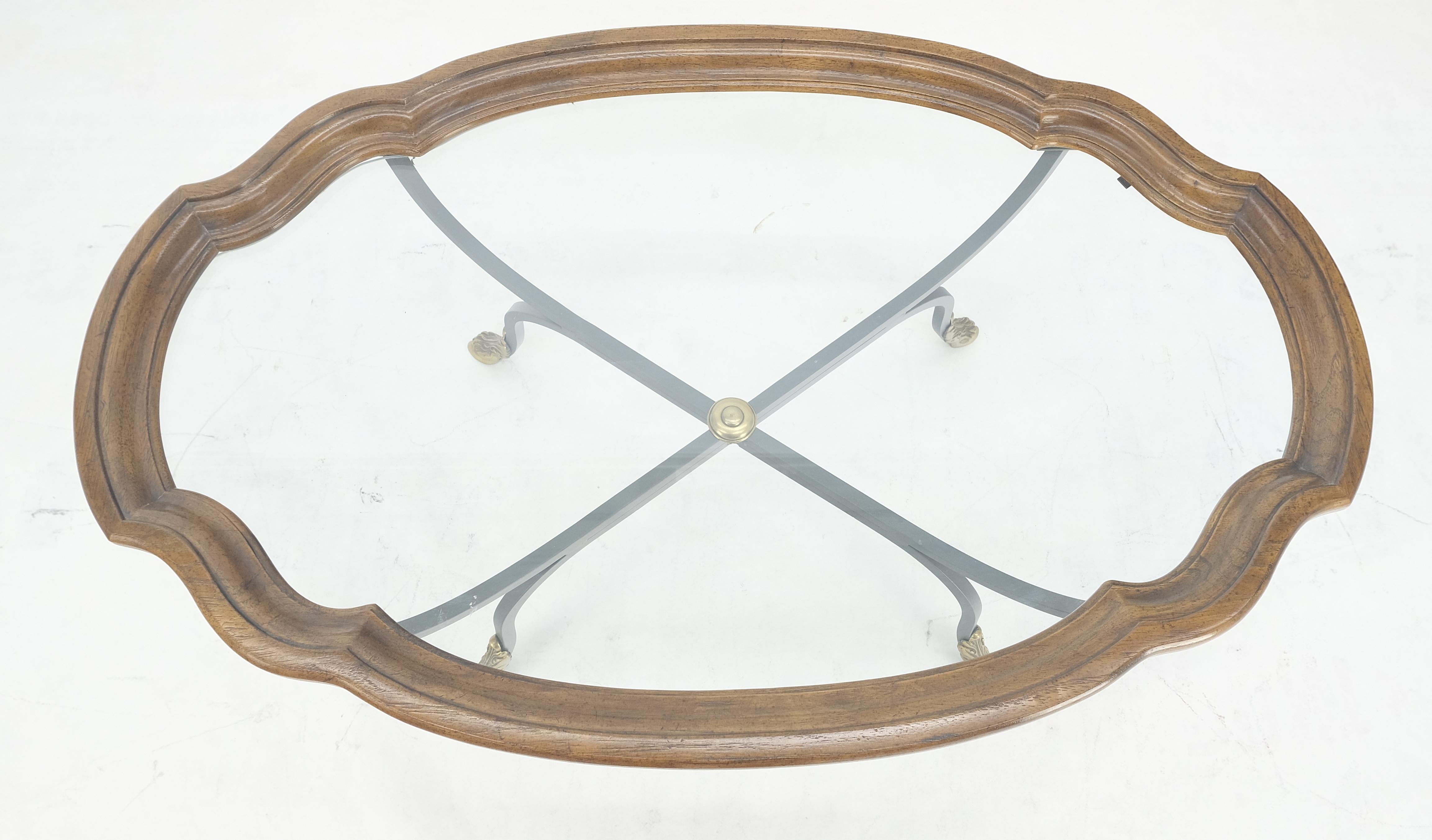 20ième siècle Table à café en fer forgé avec pieds en laiton, plateau en verre, forme ovale et festonnée, 39