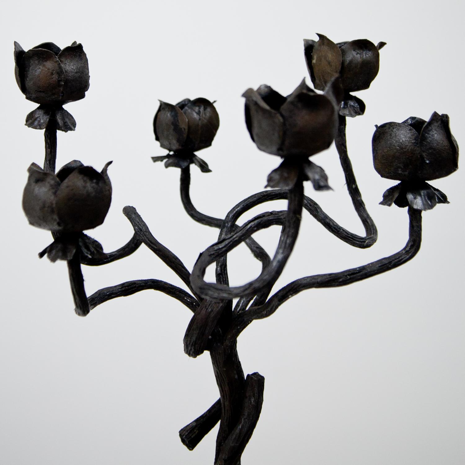 Tall, wrought iron candleholder, attributed to Alessandro Mazzucotelli (1865–1938), first half of the 20th century. The candleholder stands on a trefoil base made out of curled stylized roots and has a turned shaft. The top consists of six branches