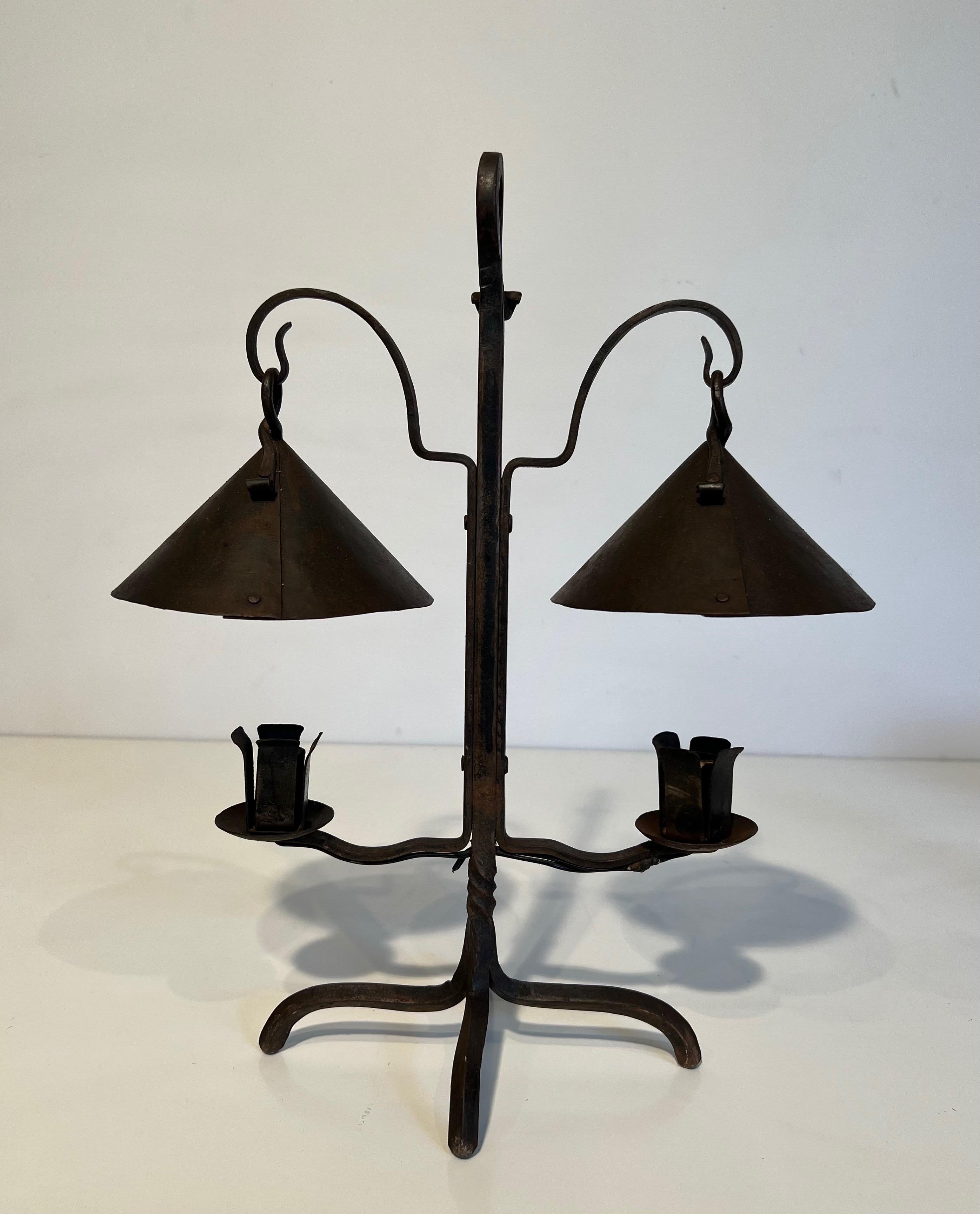 Ce très beau et unique chandelier est en fer forgé. Ce chandelier comporte deux lumières surmontées de coupes coniques rivetées. Il s'agit d'une belle ferronnerie française. Circa 1950