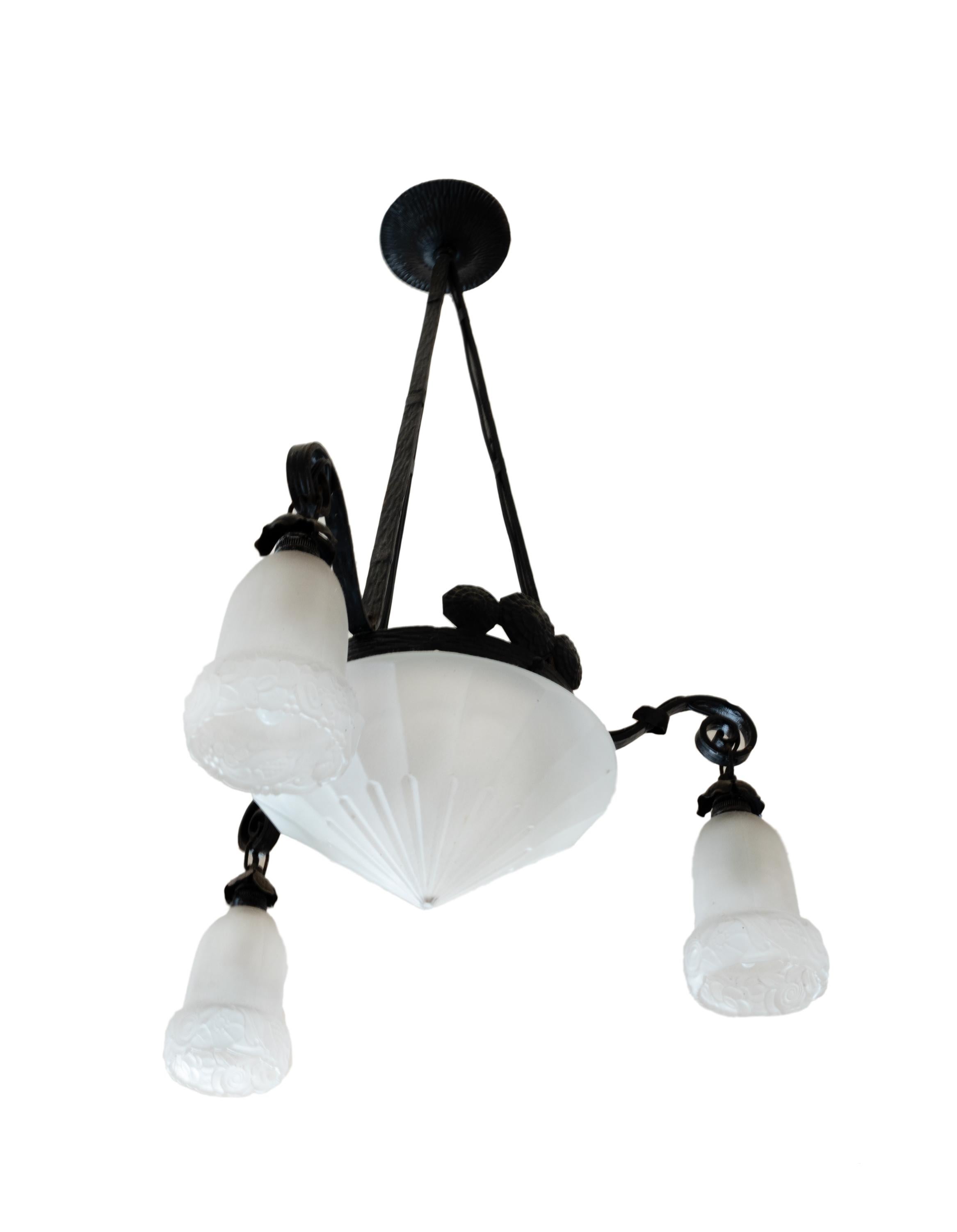 This early 20th century ceiling lamp features a solid hand-forged iron frame in the Provençal style, paired with frosted glass shades. 

This hand-forged iron chandelier features an elegant structure with four lights and original frosted glass
