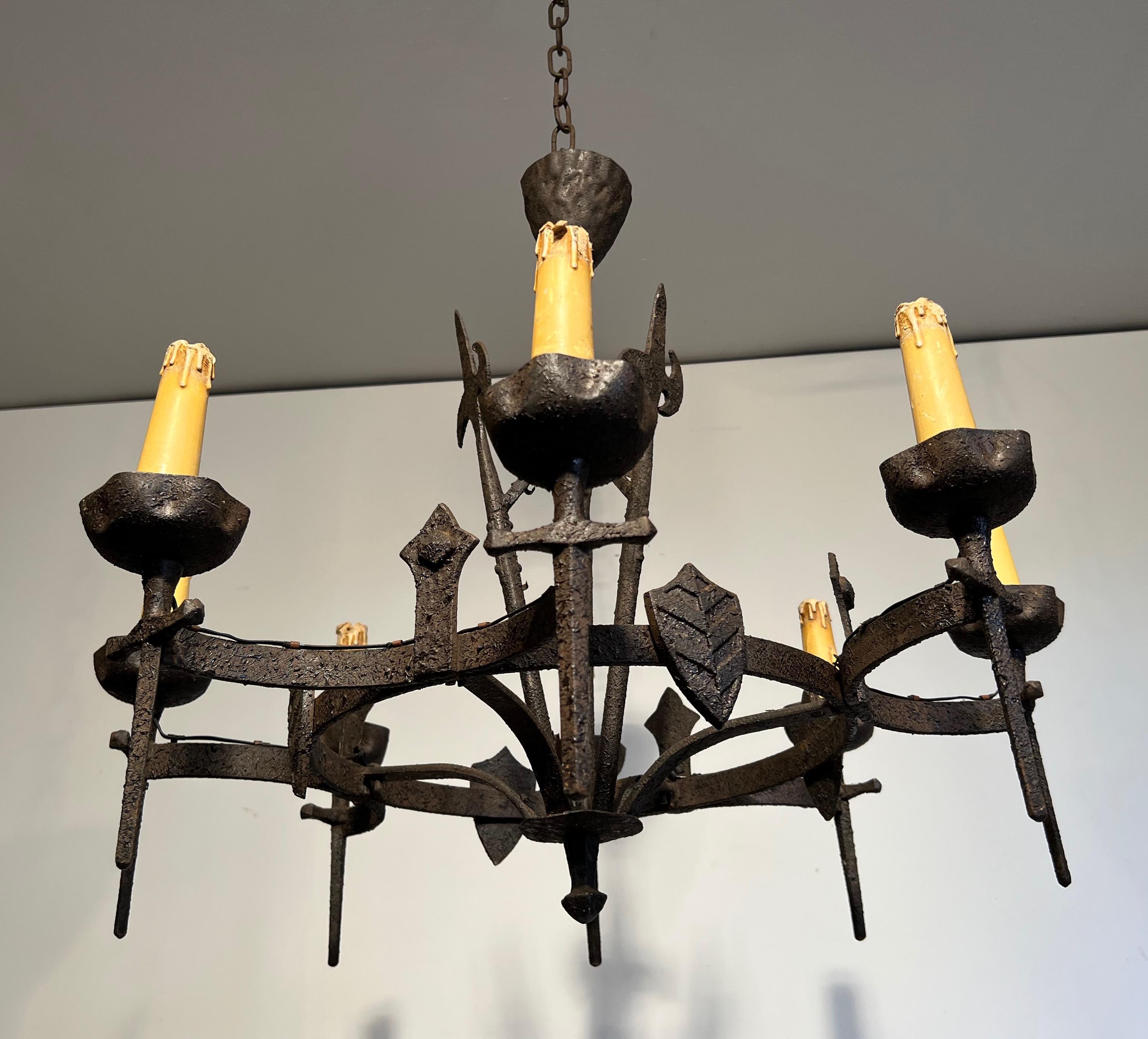 This chandelier is made of wrought iron. This is a chandelier with 8 arms in the Gothic style. This Chandelier is part of a pair of chandeliers but can be sold individually. This is a French work. Circa 1950