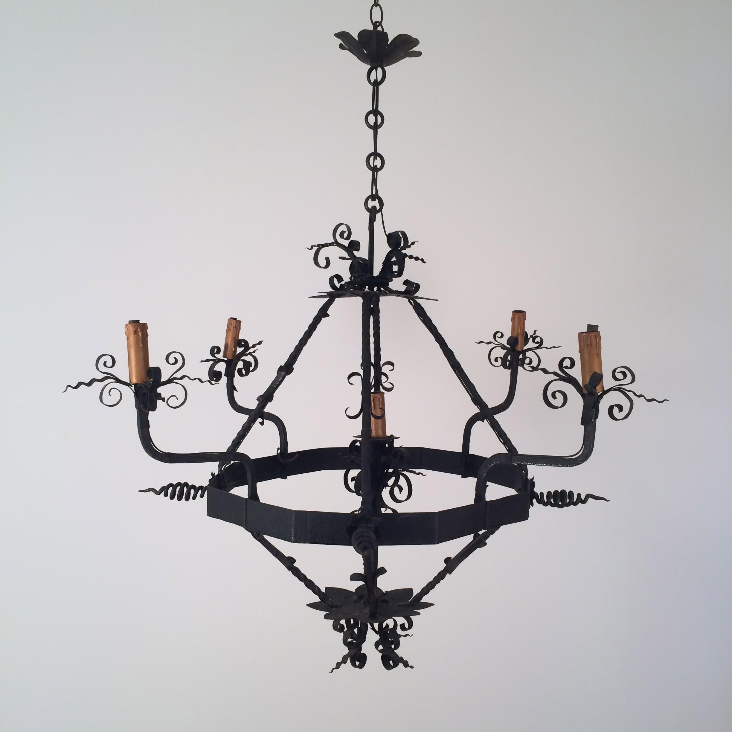This nice and decorative 5 lights chandelier is made of wrought iron. This is a French work, circa 1940.