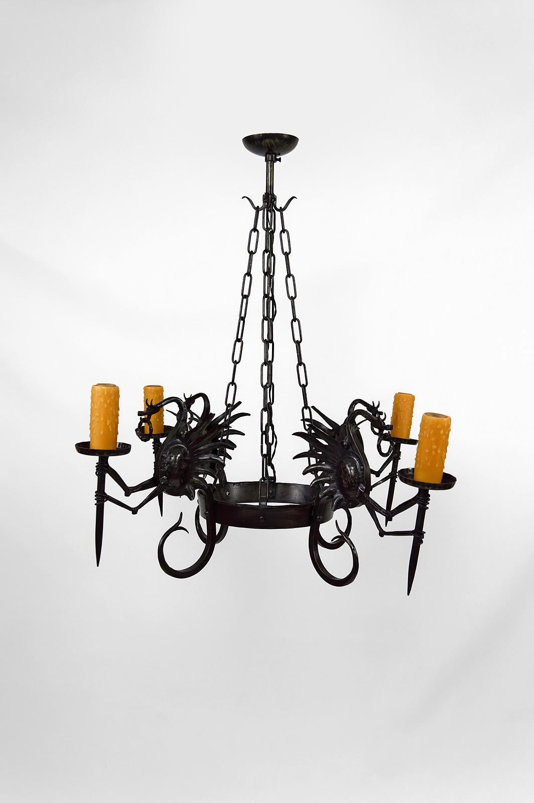 Superb wrought iron chandelier / pendant composed of 4 winged dragons each holding a torch / torchiere.

Good quality of manufacture: well-made subjects, beautiful patina of the metal.

Neo-Gothic / Art Nouveau / Liberty style, Italy, circa