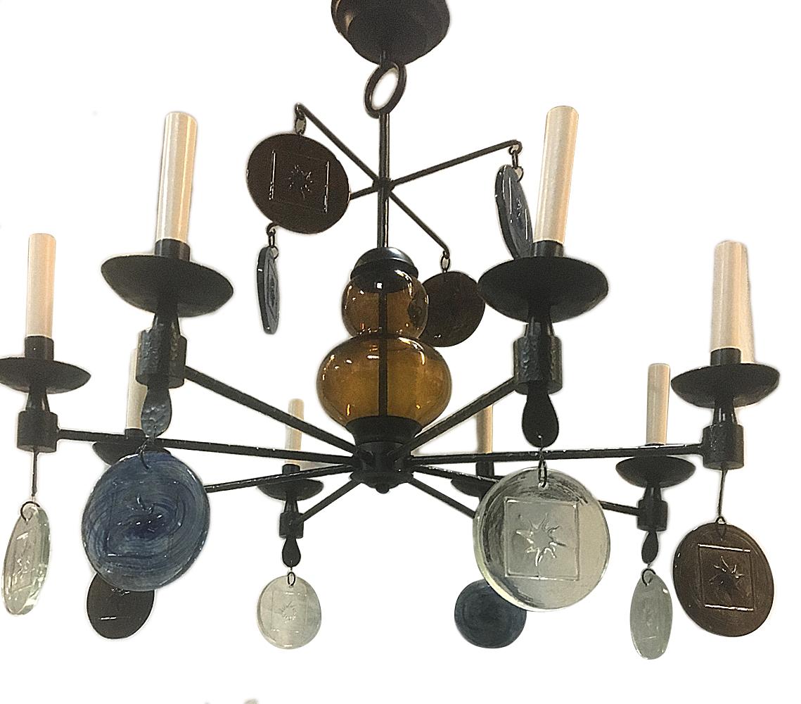 A circa 1960’s Swedish eight-light wrought iron chandelier with painted finish and molded glass pendants in blue, amber and clear.

Measurements:
Diameter: 32″
Min. Drop: 30″