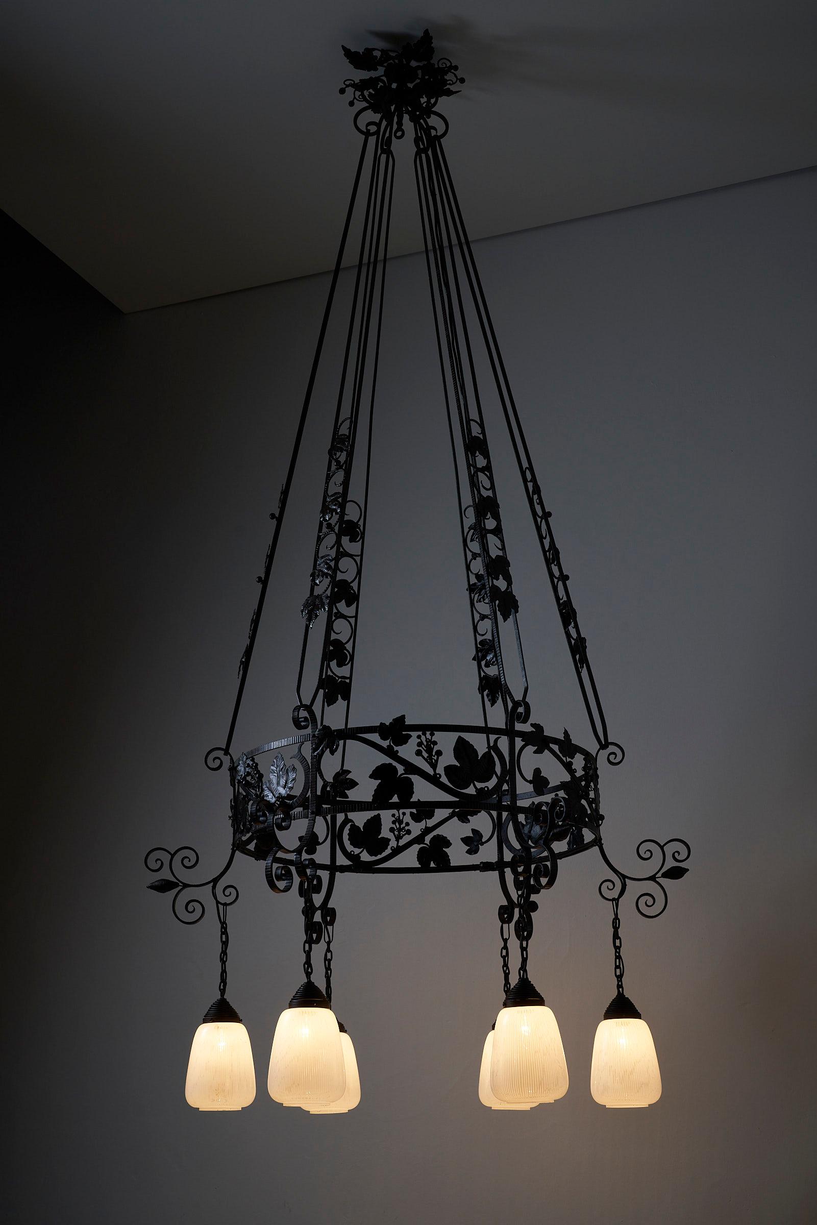 Introducing a stunning Wrought Iron Chandelier adorned with delicate Wine Leaves, a grandeur piece that comes around only once in a while. Ideal for evoking a sense of high end antique opulence in older castle-inspired settings or within high-end