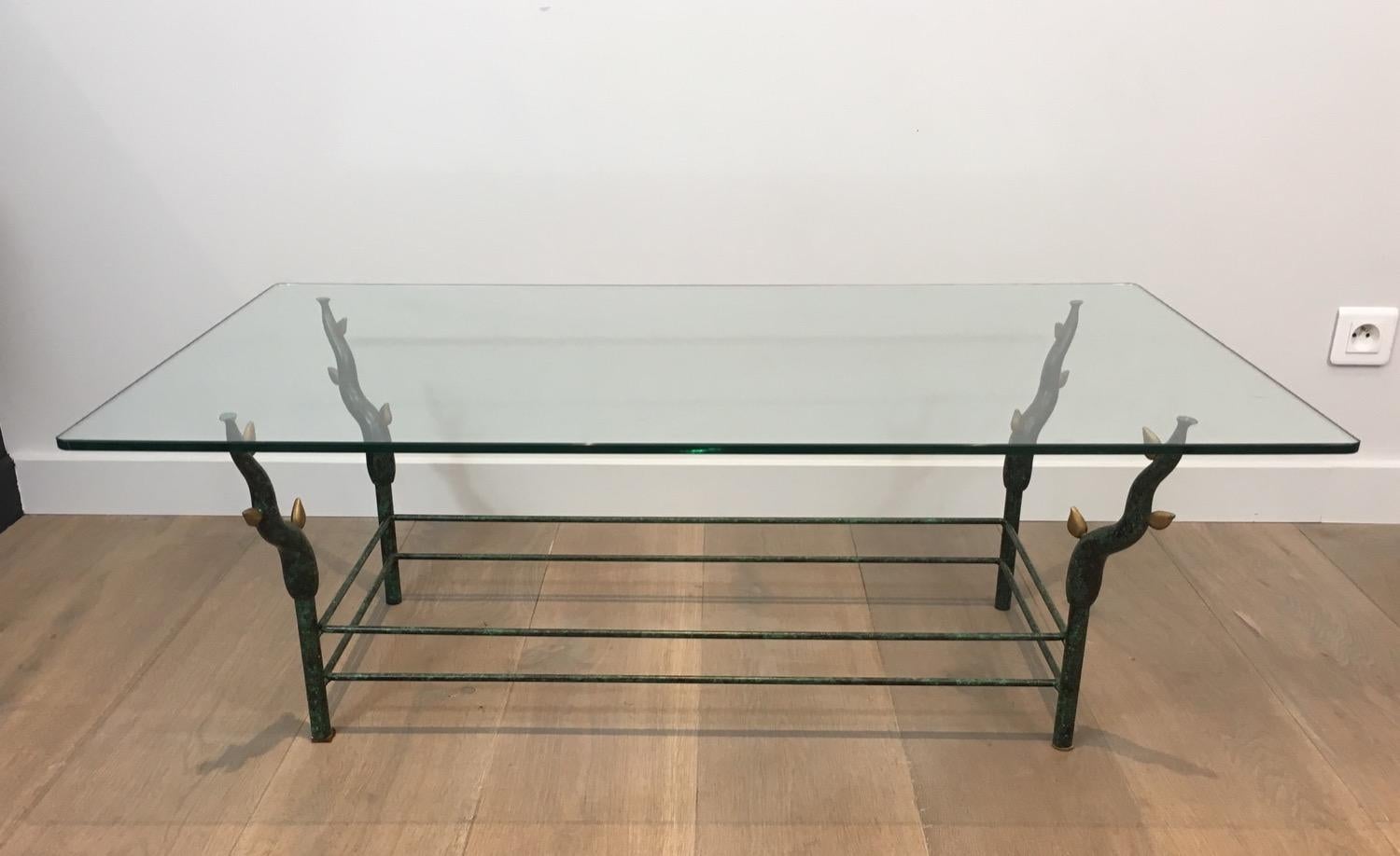 Cette table basse insolite est composée de fer forgé laqué noir et de branches d'arbre dorées avec un plateau en verre. Il s'agit d'une œuvre française, dans le style de Willy Daros. Circa 1970.