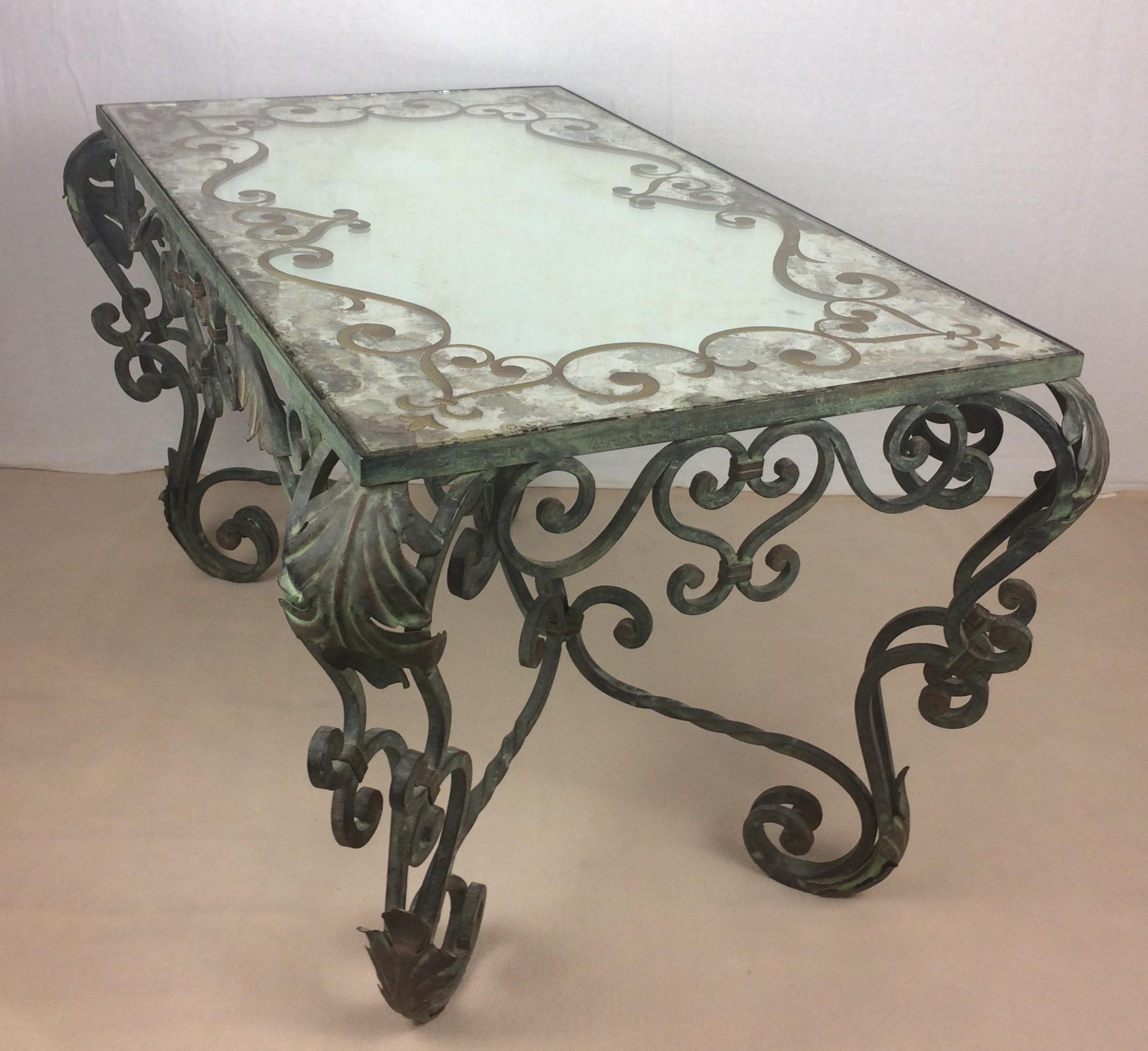 Wrought iron coffee, side or end table with églomisé mirrored top attributed to Gilbert Pollierat, France, 1940. 

This table has an elegant design with pure lines and accents. It is very heavy and finely executed with scrolled details and