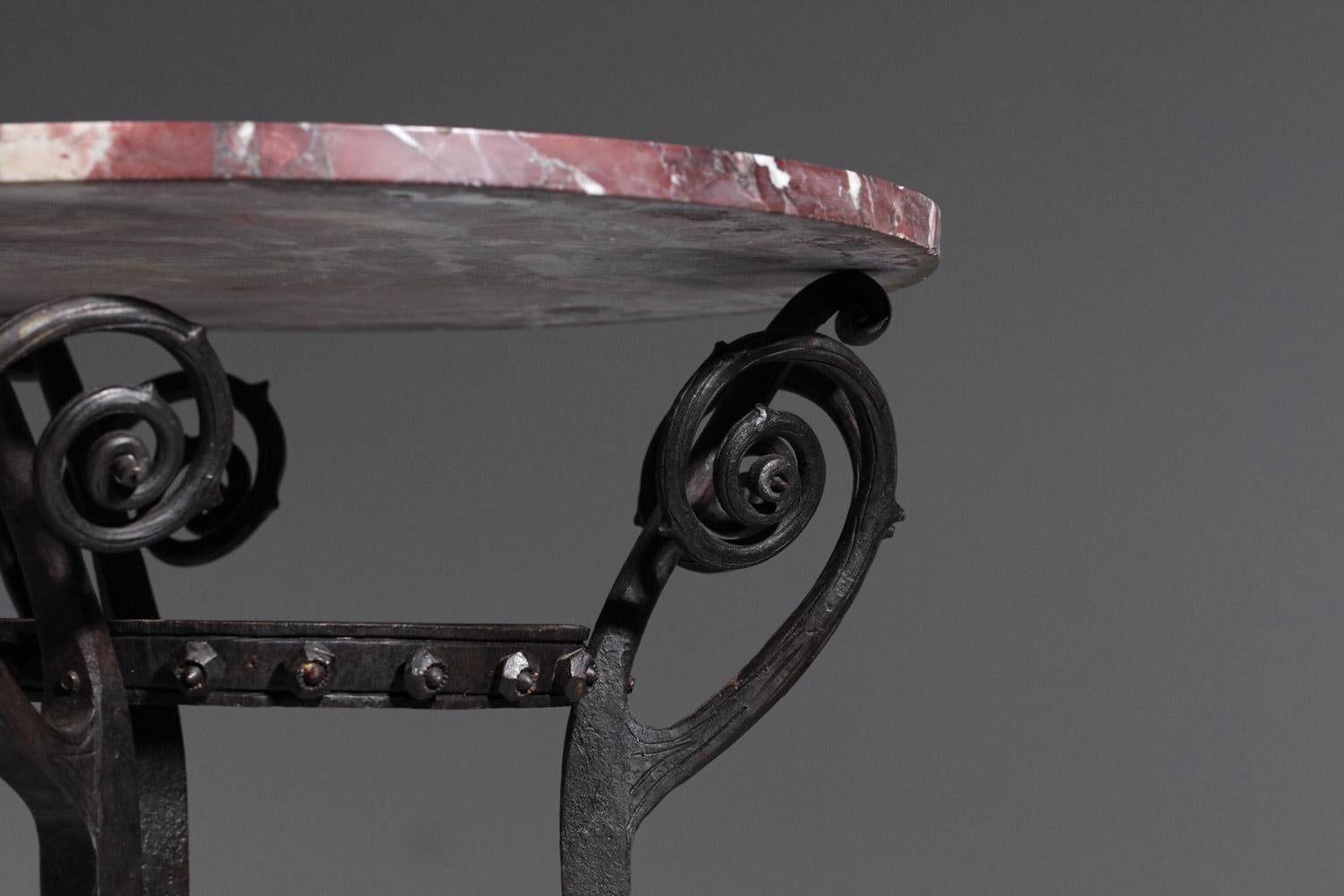 French Art Nouveau style stand from the 1930s/1940s. Round top in speckled red marble, wrought iron base with a central decoration reminiscent of rose branches and lion's paw feet. High-quality workmanship with beautiful craftsmanship details. Very