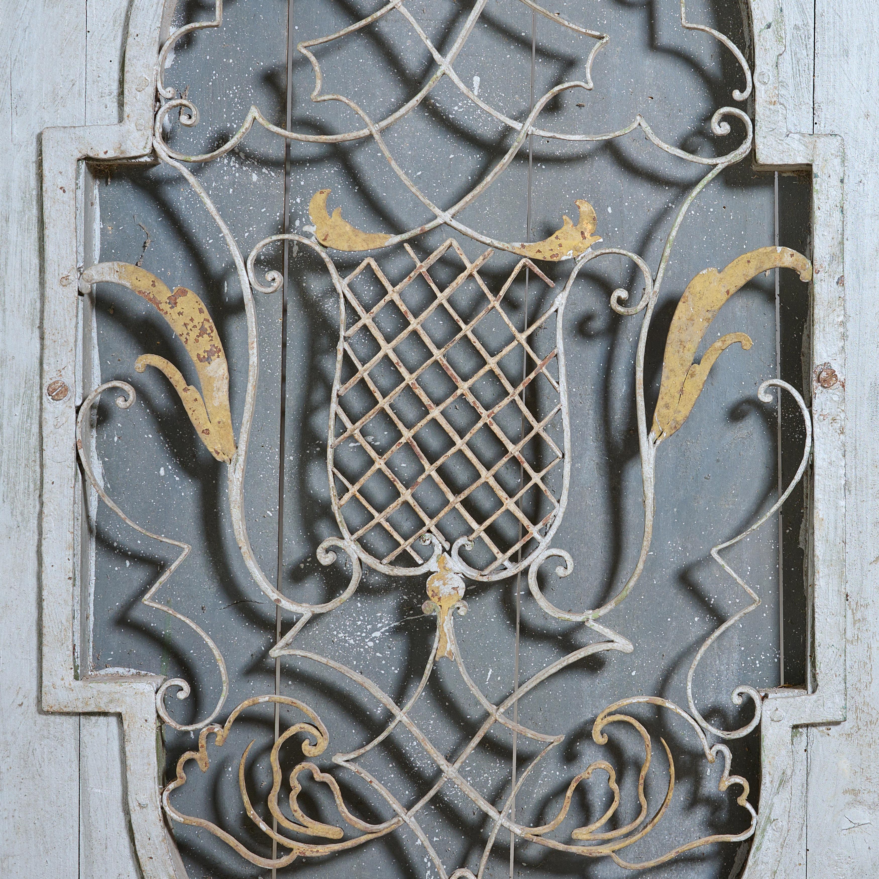 Wrought iron decorative grill with original wood panel and paint.