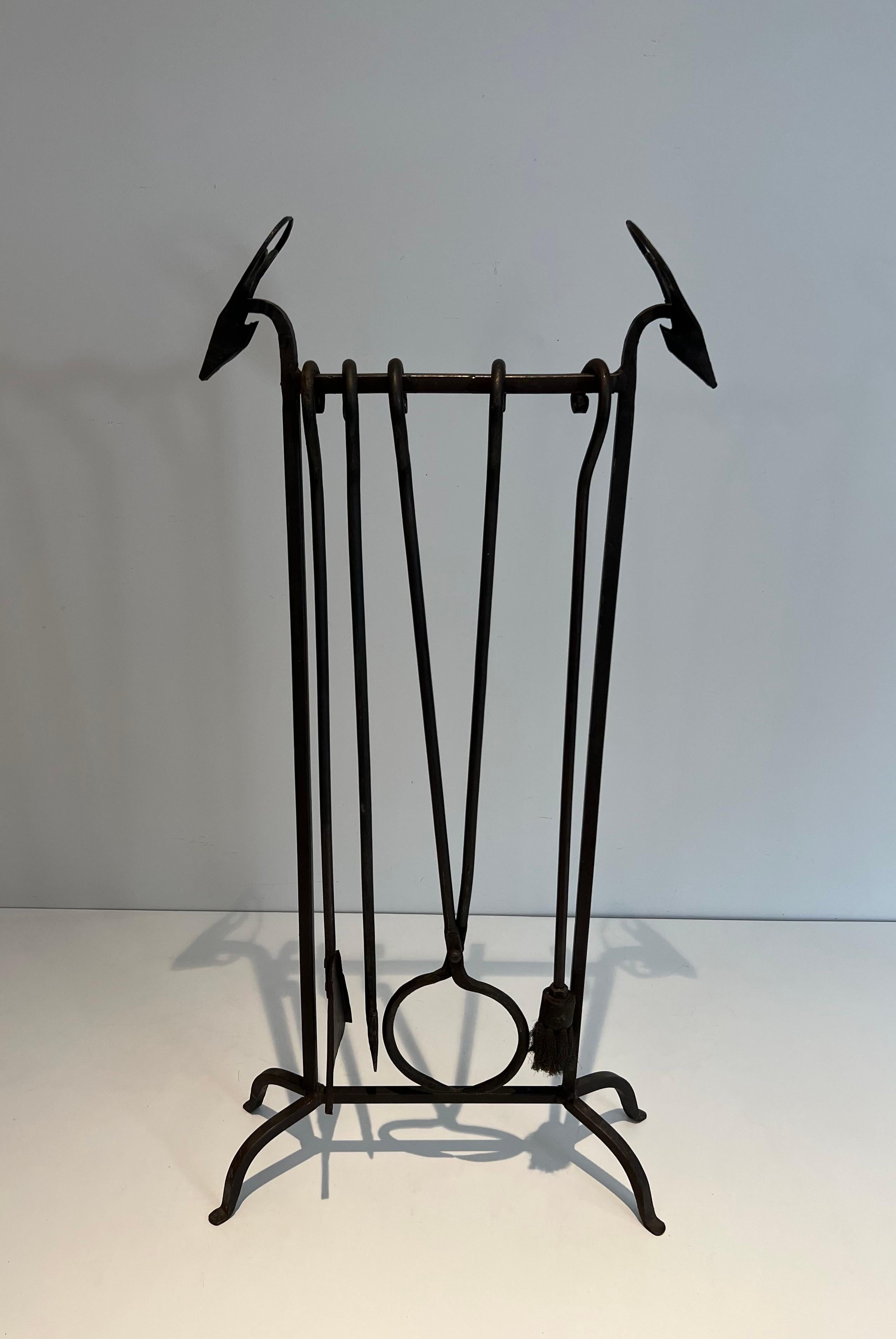 Ces outils de cheminée à tête de cerf stylisée sur pied sont en fer forgé. Il s'agit d'une œuvre française dans le style d'Edouard Schenck Circa 1940.
