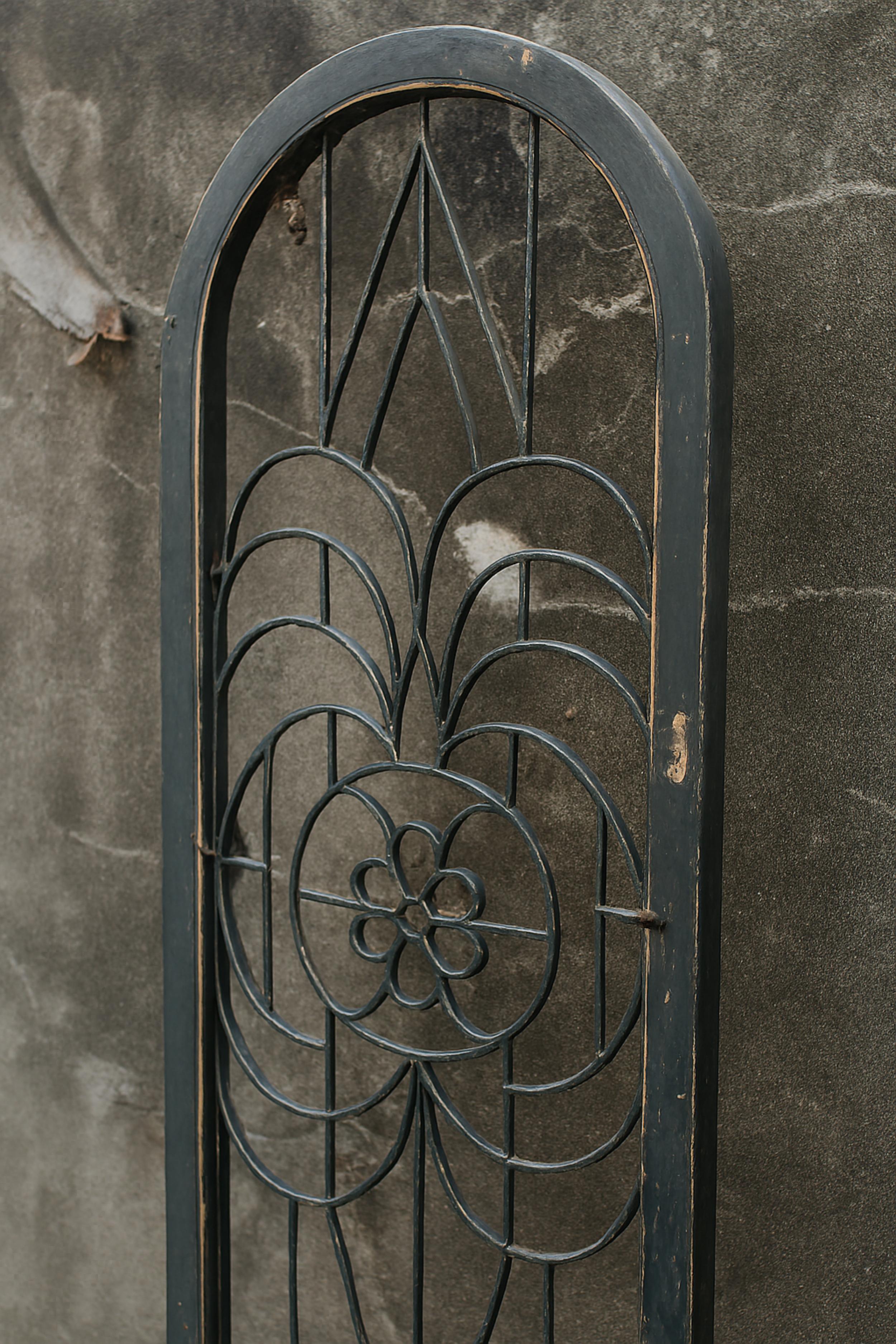 A wooden door from the mid 20th century with iron floral  panels and original finish, hand-forged from heavy wrought iron flower drawing. The door would be perfect on rails or mounted in an entrance or decor pieces. The appropriate hardware would