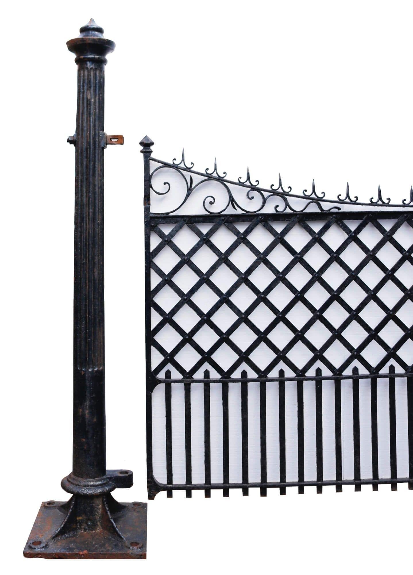 An elegant set of reclaimed wrought iron gates with accompanying cast iron posts to set the stage for a beautiful driveway in a country home or townhouse. Delicately made from wrought iron, each gate features a sweeping top with ornate scrolling