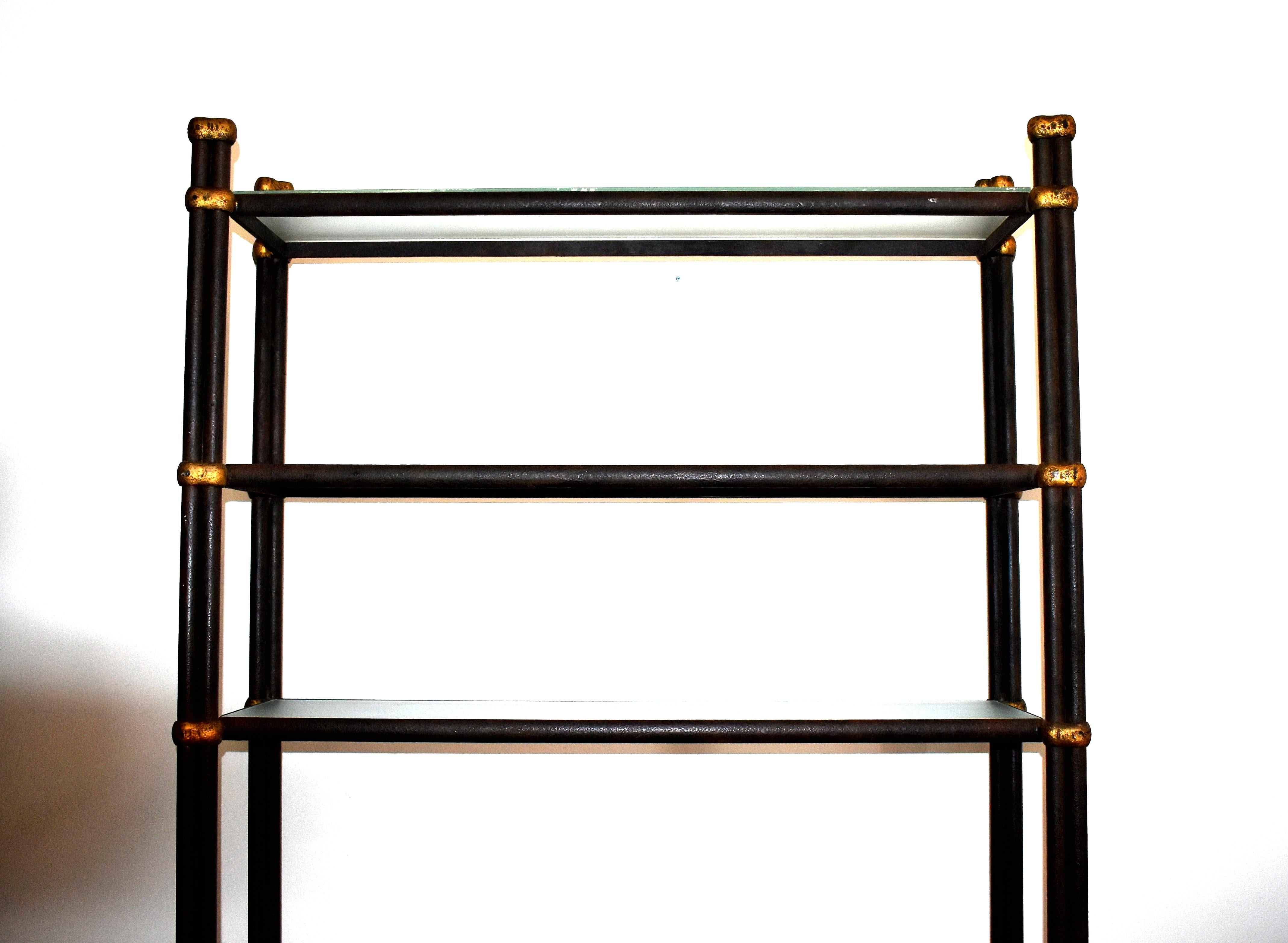 Wrought iron tall and narrow shelf unit. Elegant freestanding shelf of wrought iron with textured glass and gold detail finish. Architectural etagere features six rectangular shelves.