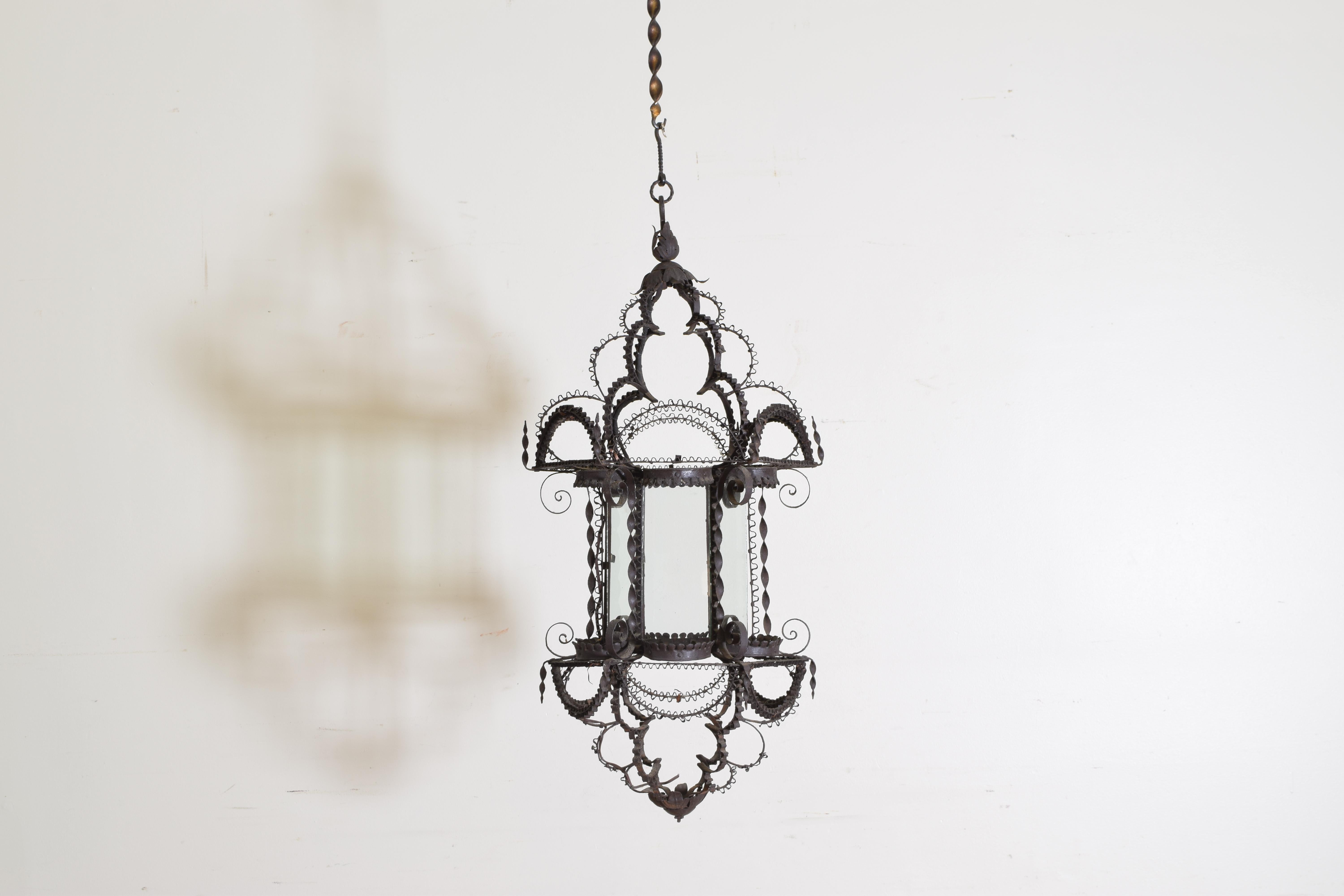 From the Baroque revival period this lantern is unusual with raised crenelated metal work atop an iron structure, the hexagonal center retaining glass panels.