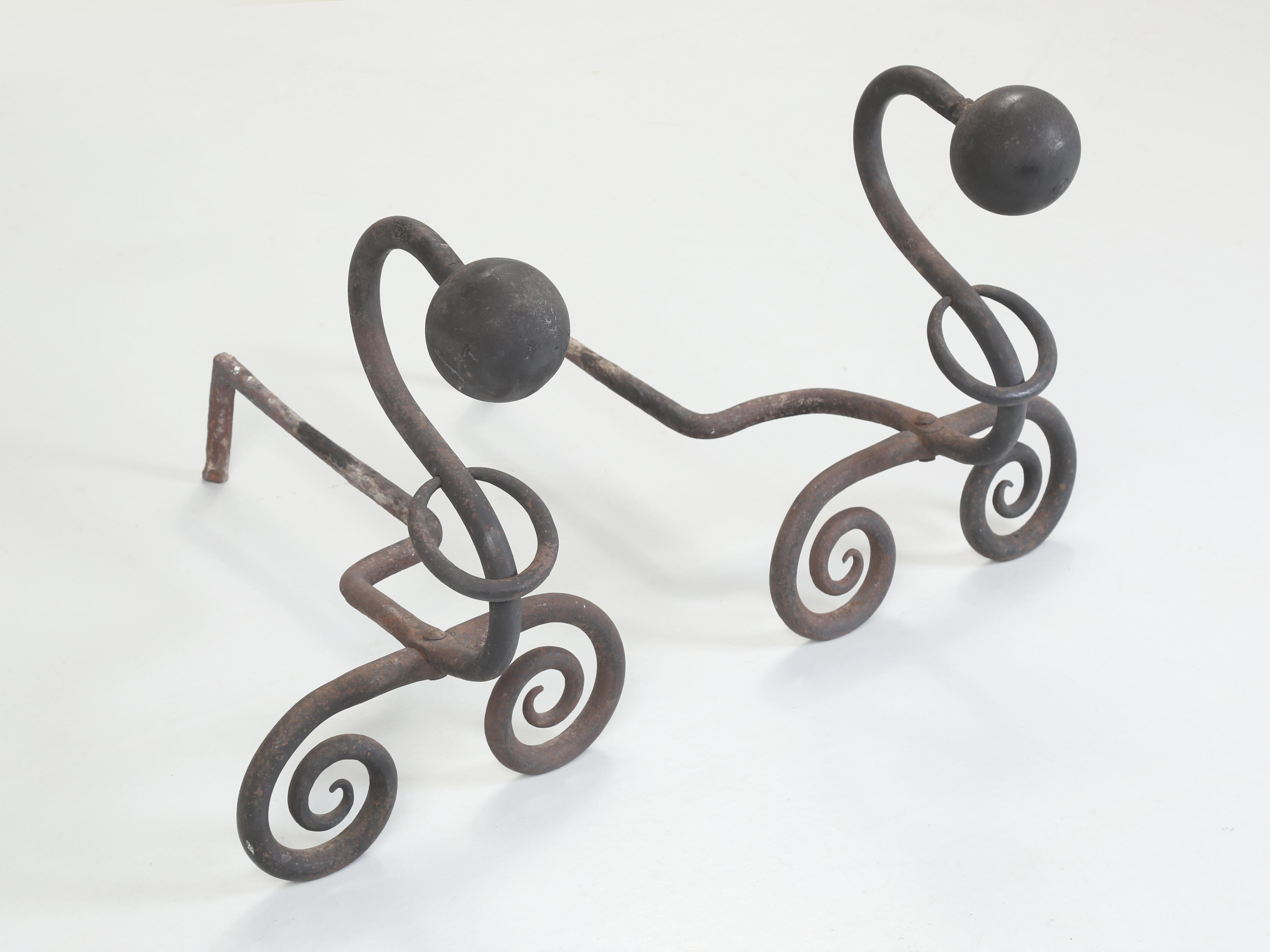 Wrought Iron Fireplace Andirons. Modernist style with a curled form and sphere tops. hard to pinpoint when they were made, but they seem to have a bit of that French 40's style about them, so that's our best hypothesis about their origin. You can