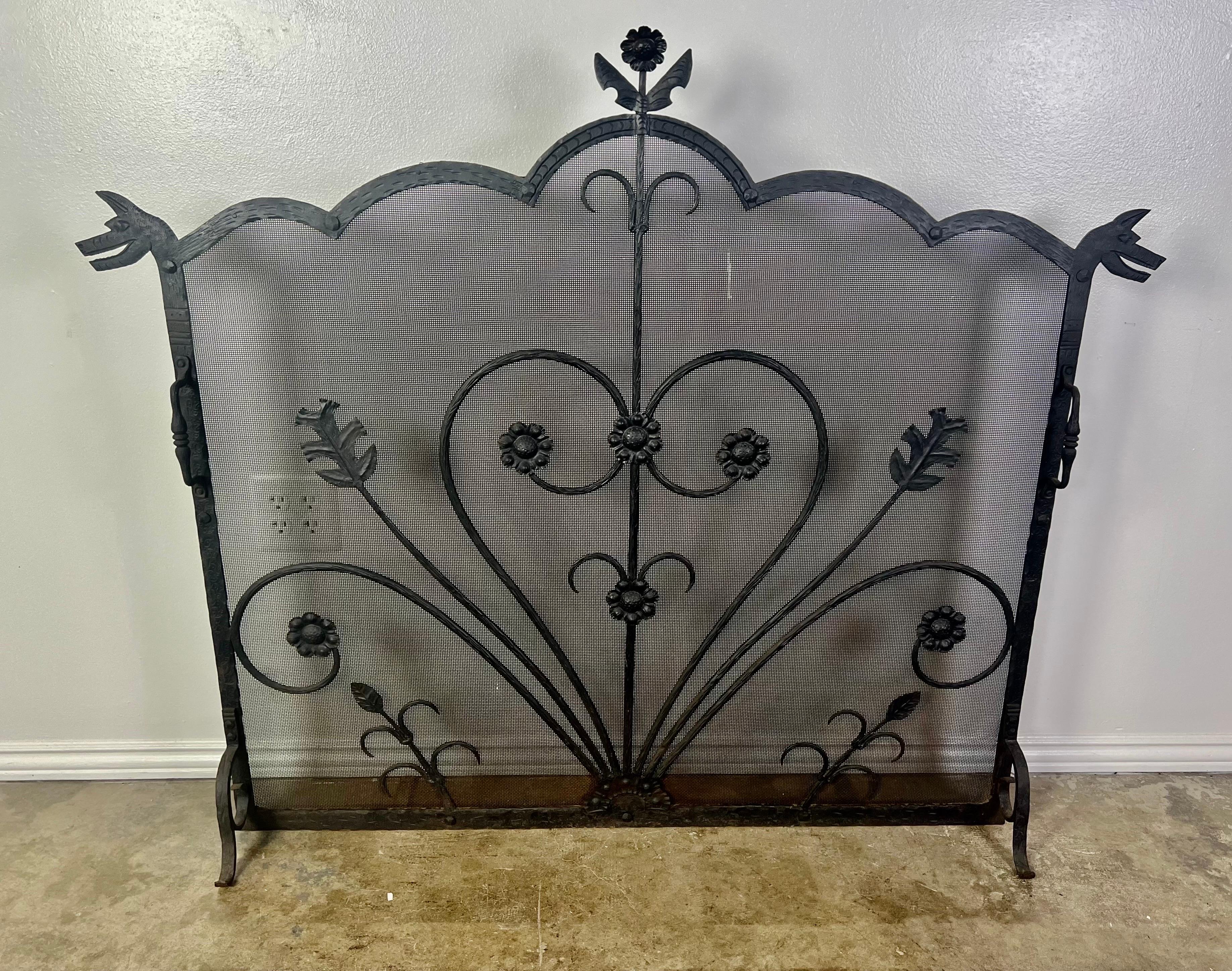 Large fireplace screen with dog handles and wrought iron frame. Decorated with hearts and flowers.