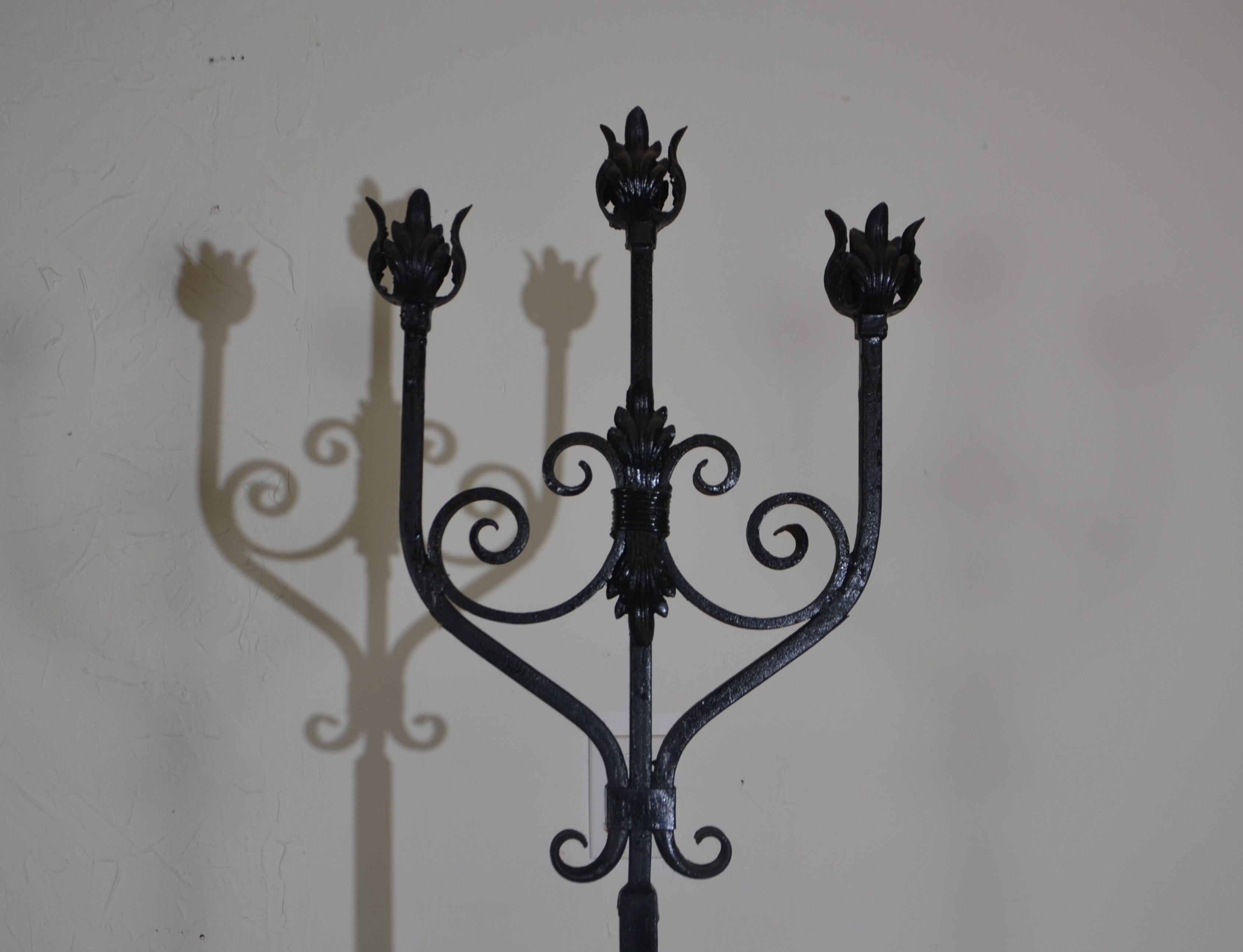 Pair of wrought iron floor torchieres with three arms.
