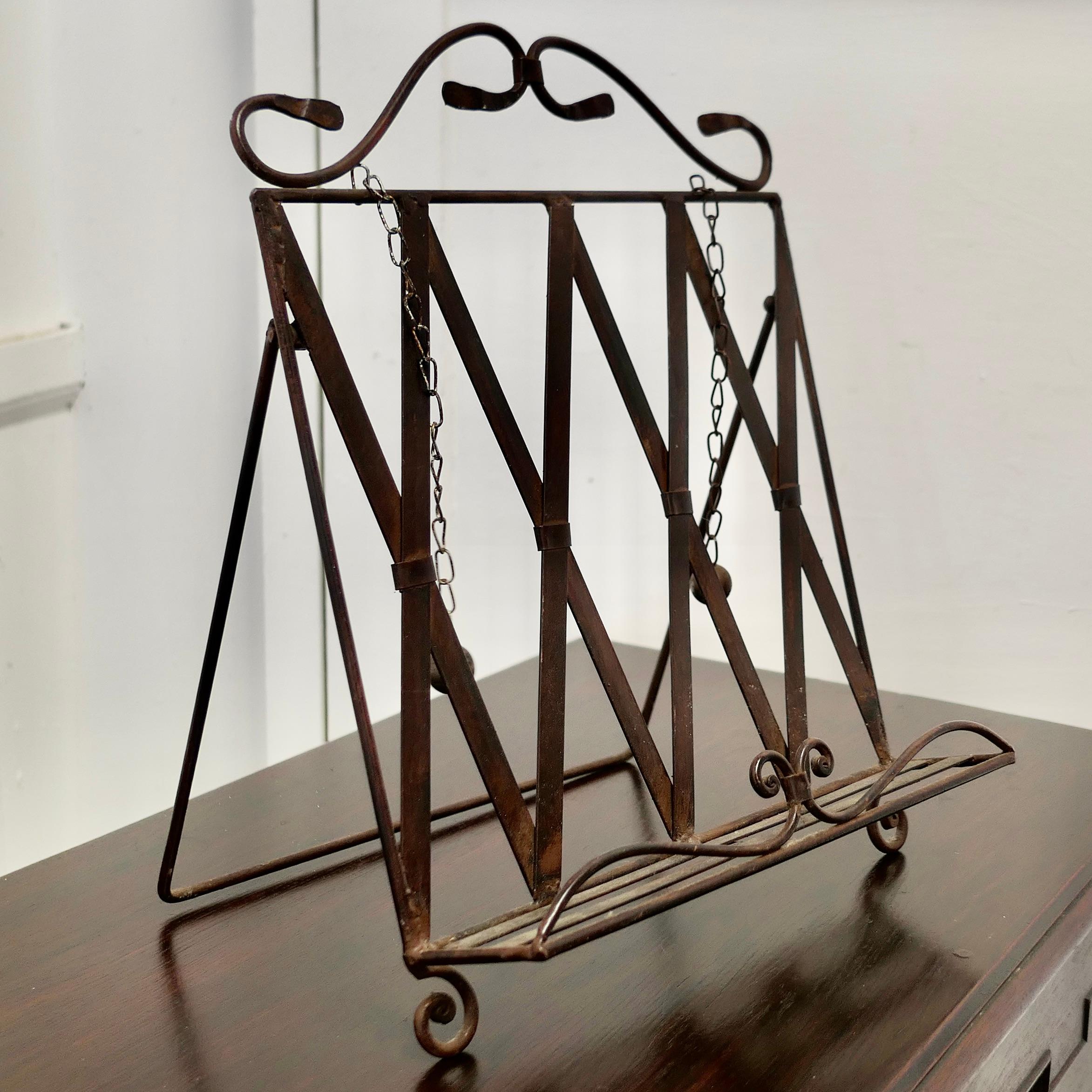 Wrought Iron Folding Book Rest, with Page Weights

This is a charming piece, it is made in Wrought Iron the stand has an angle setting and a front rail to keep the page open, 2 ball weights hang from chains to keep the book open 

A charming piece