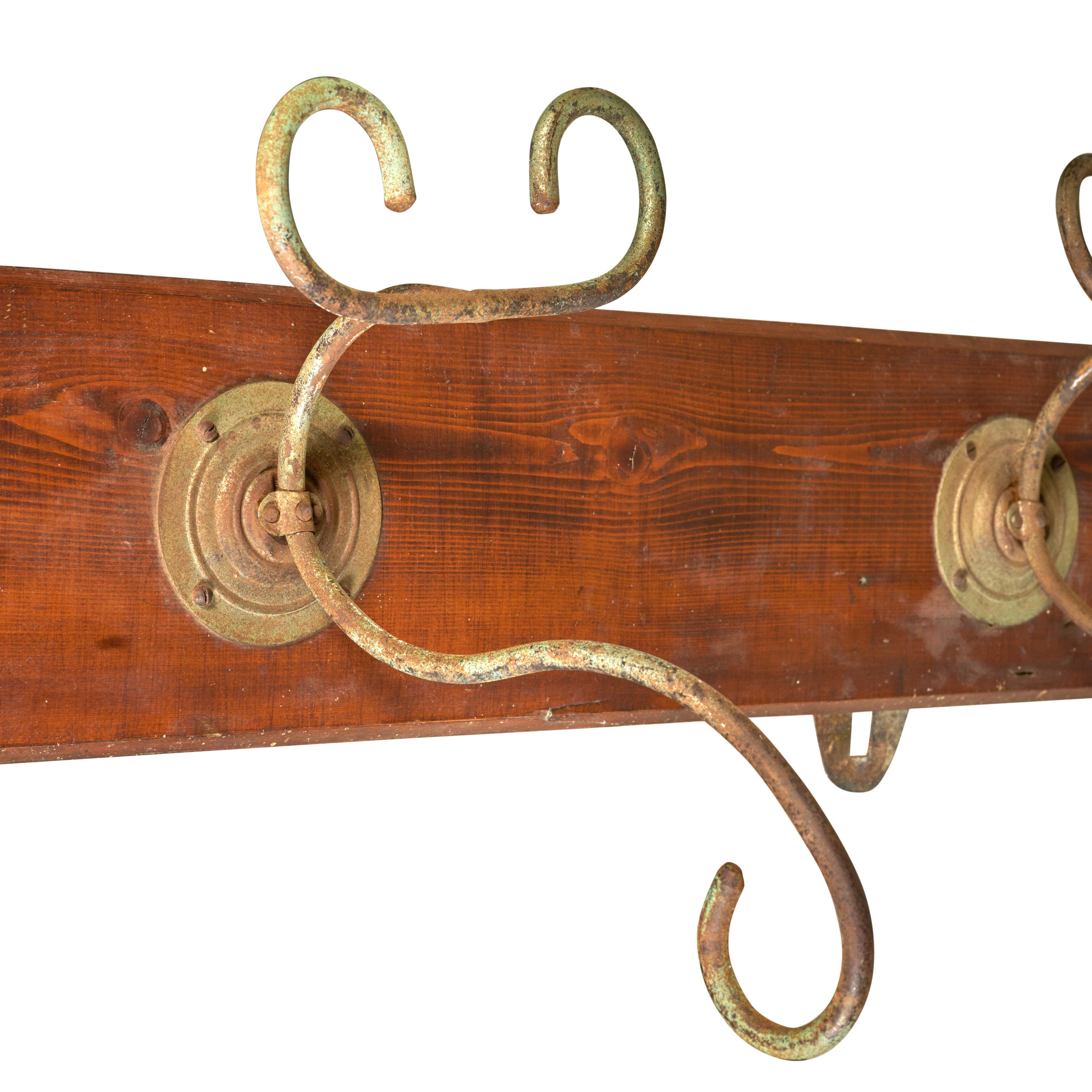 Four hook coat/hat rack - wrought iron and wood. Wall mounted. 