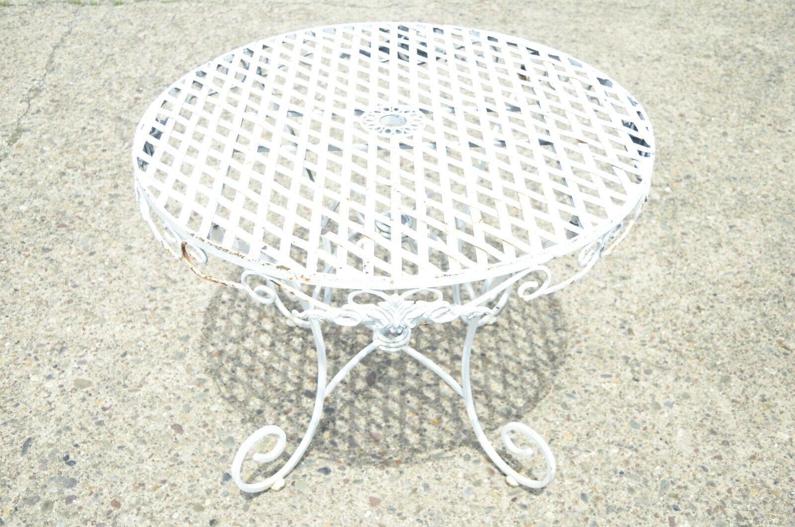 Wrought iron French Pastry style country lattice scroll round patio dining table. Item features a center umbrella hole, lattice design, scrolling base, lift off top with folding base, great style and form. Circa late 20th century.
Measurements: 30