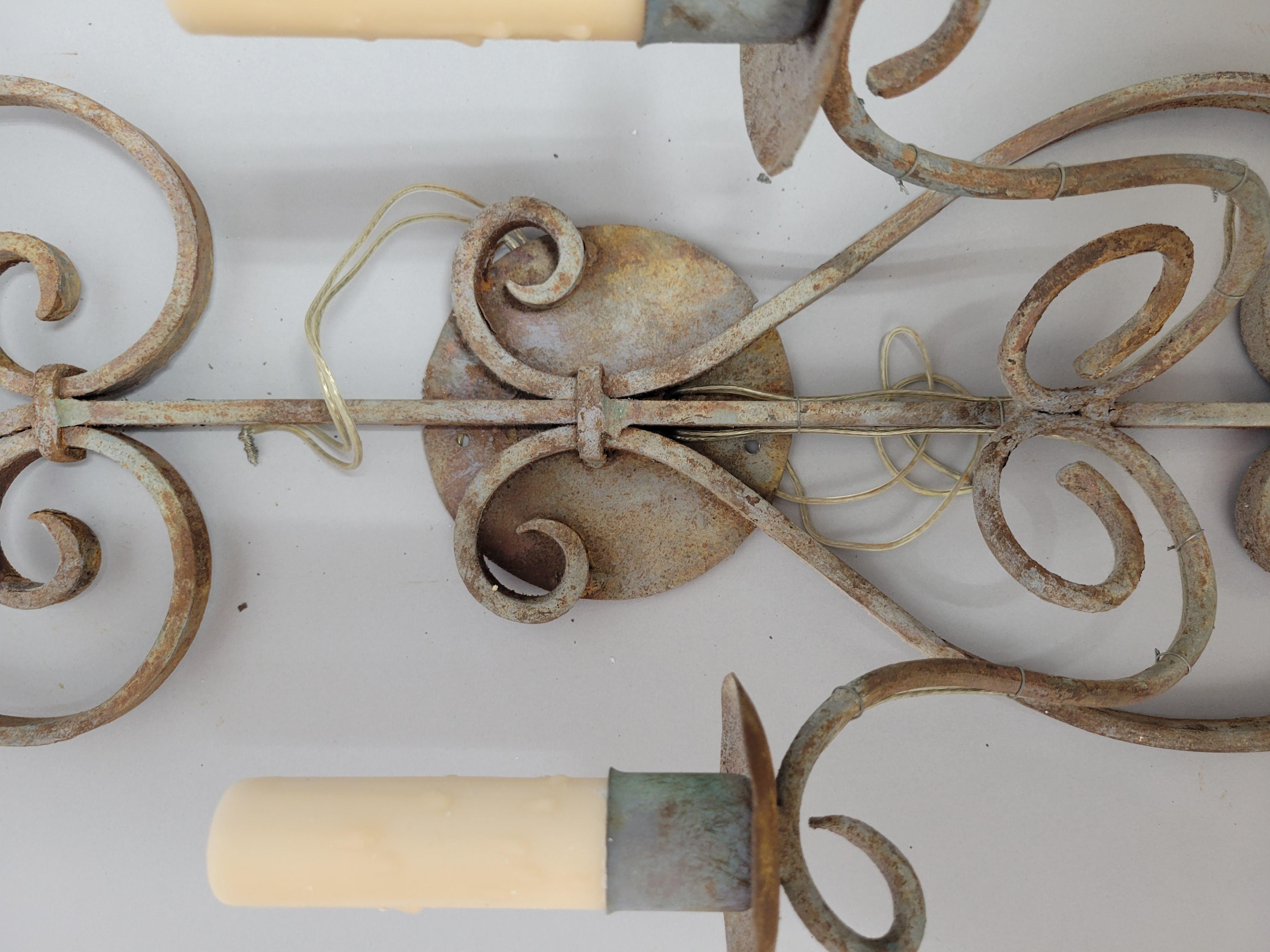 Cette applique murale en fer forgé antique rehausse votre décoration intérieure. Cette pièce intemporelle présente des volutes complexes et une belle patine qui ne vient qu'avec l'âge. L'applique a été professionnellement électrifiée pour accueillir