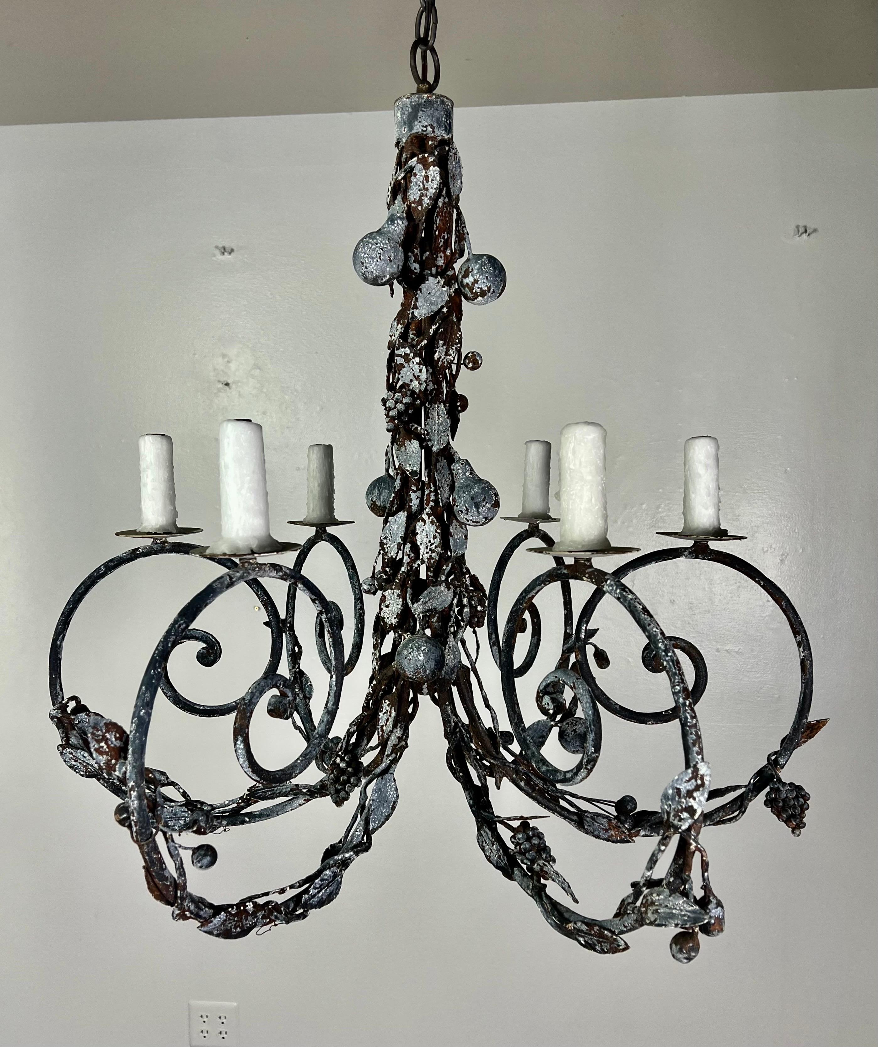 Six light painted wrought iron chandelier by Ironies. The six scrolled arms are adorned with fruit and foliage and continues up the body of the chandelier. The fixture is newly rewired with drip wax candle covers. It includes chain & canopy.