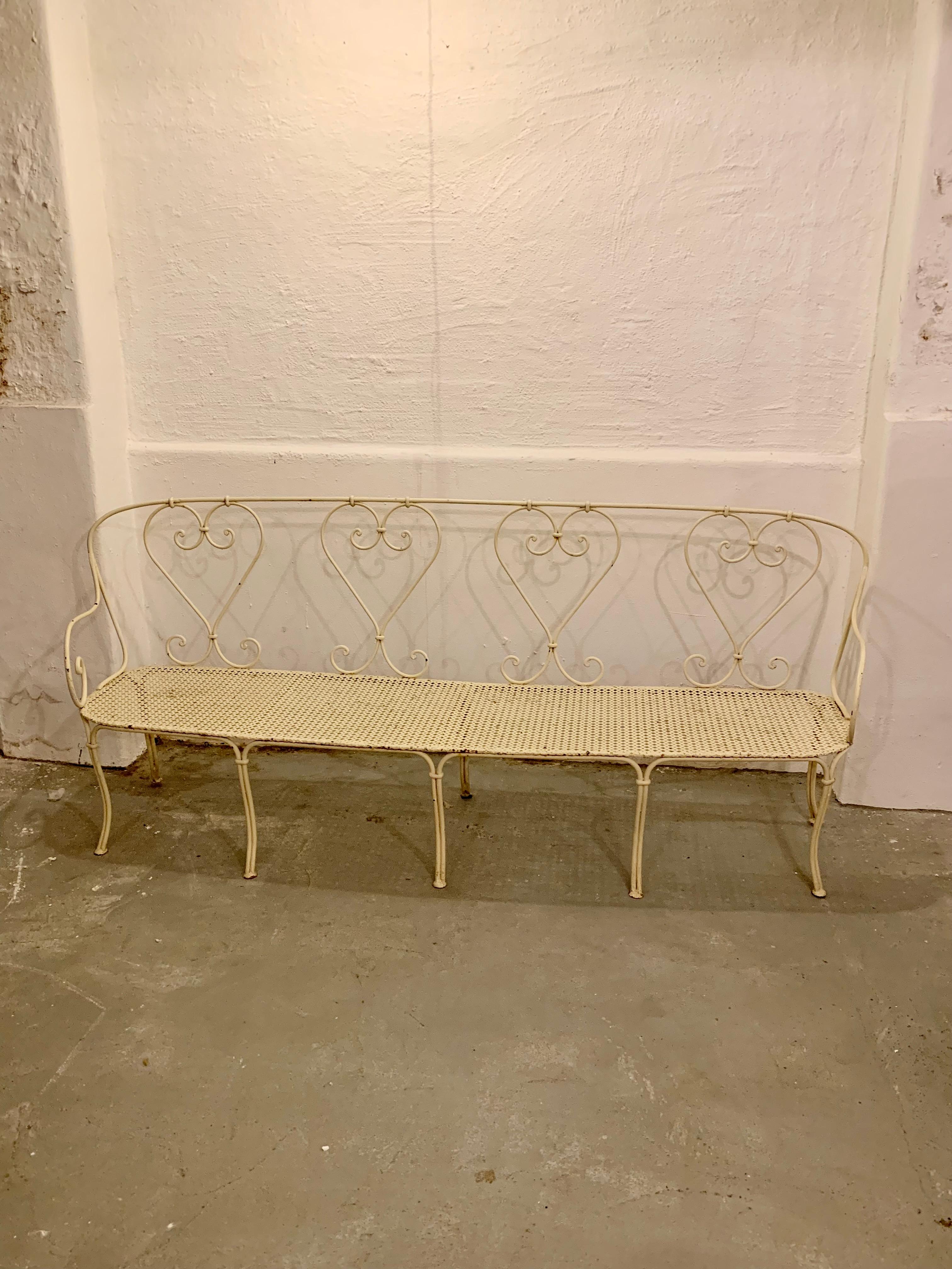 Wonderful large wrought iron garden bench. The antique white painted (egg shell) French bench is in very good condition and has great patina.