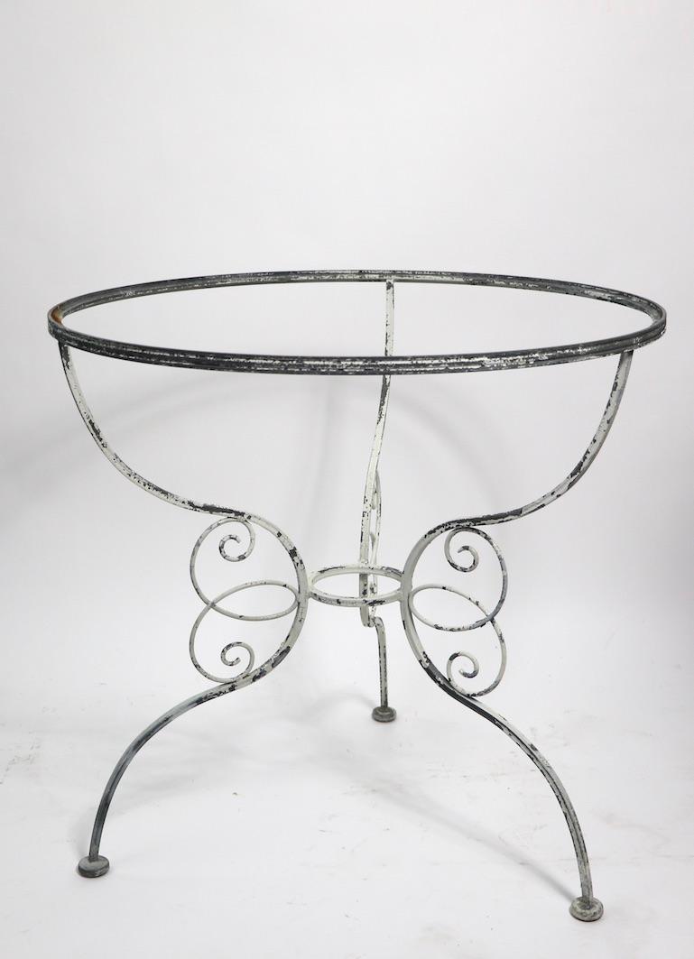 Charming garden, patio, table having an ornate wrought iron base and glass top (glass has flaws please see images) well executed metalwork, possibly Salterini, Woodard, Leinfelder etc. - unsigned. This table can function as a cafe, breakfast, dining