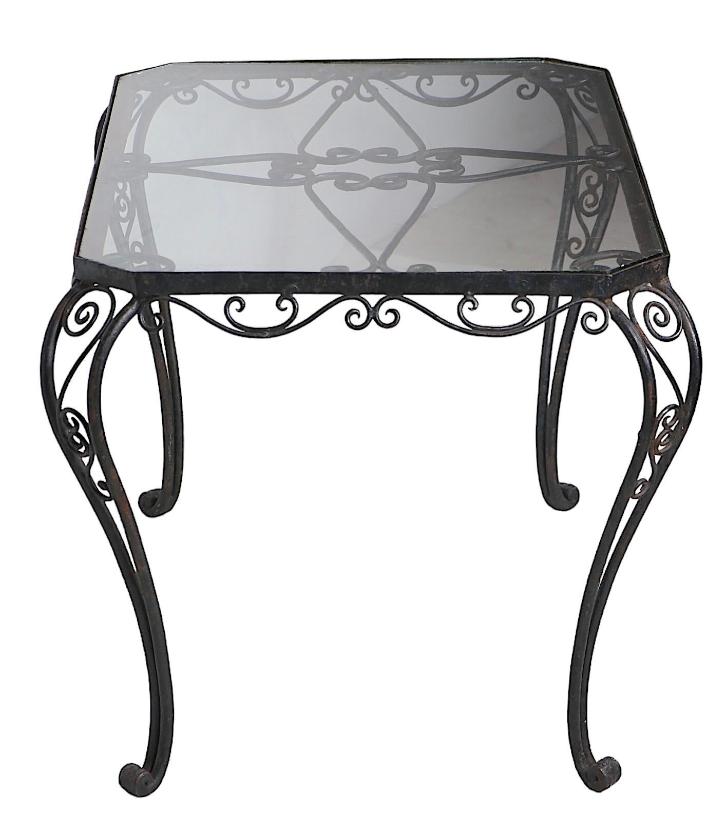 Exceptional ornate wrought iron coffee table with eight sided glass insert top. The table features an intricately wrought frame, which is in very fine, original condition supports the drop in glass top, top shows some flaws notably along the edges,