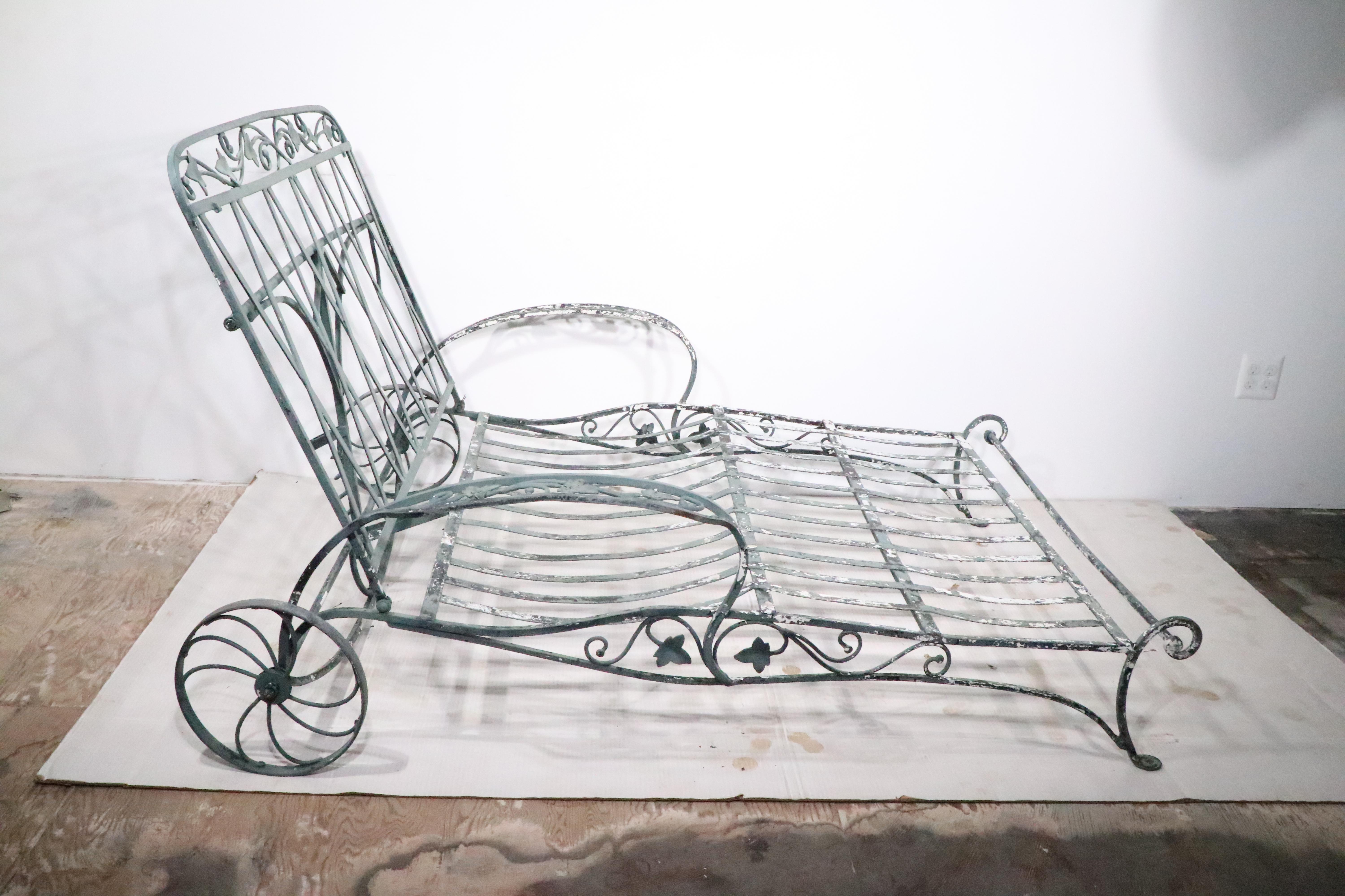 Rare wrought iron  double chaise by Salterini. The chairs features decorative foliate metalwork, an adjustable back, and rear wheels. The back support raises from a flat position, to upright  ( Lowest H 14 x H in Upright position 39 inches ).
 The