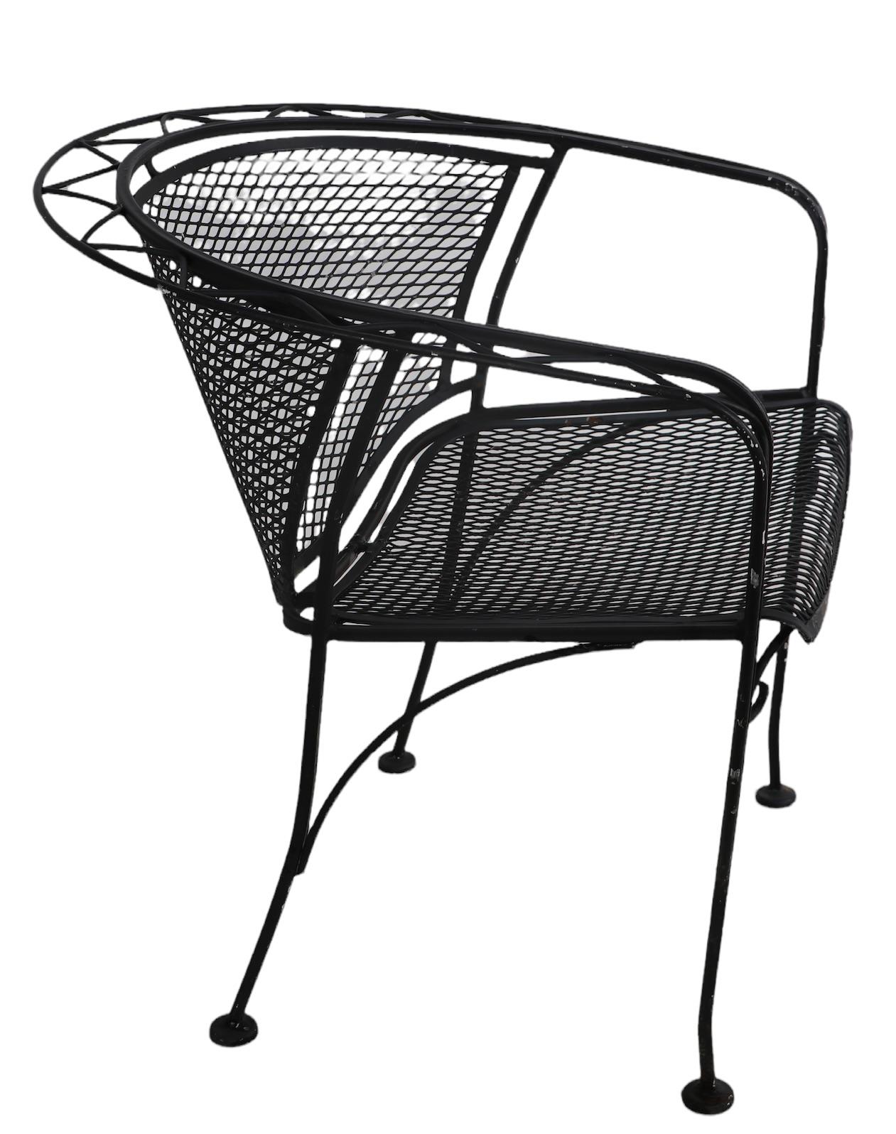 Wrought iron and metal mesh architectural garden, patio, poolside chair, by Salterini. The chair features a stylized zig zag surround trim element, wrought frame, and metal mesh seat and backrest. Structurally sound and sturdy, shows cosmetic wear