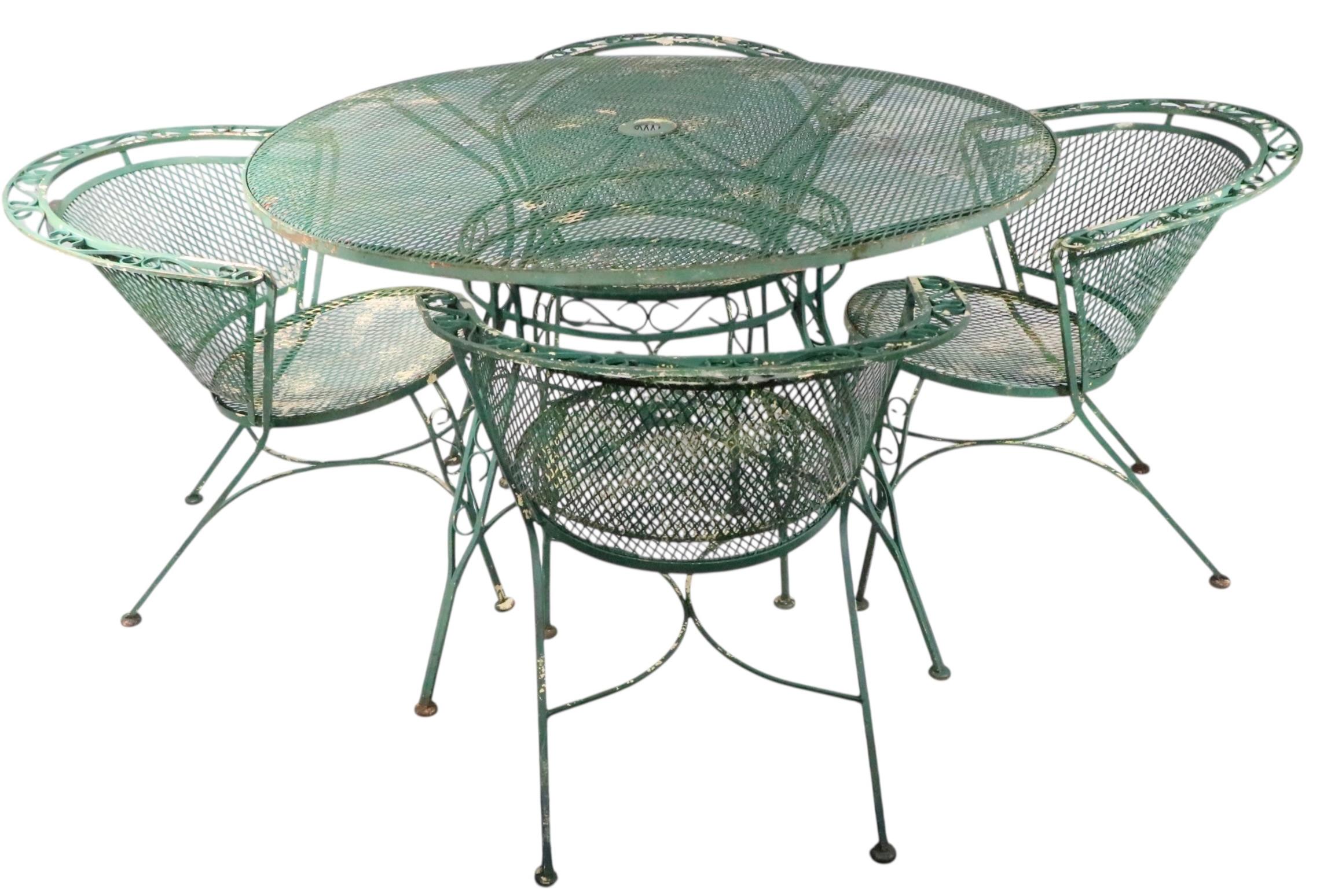 Chic Mid Century, Hollywood Regency cafe, bistro style dining table, made. by Salterini, circa 1950/60's. The table features a decorative wrought iron base with a metal mesh top. Structurally sound and sturdy, shows cosmetic wear, normal and