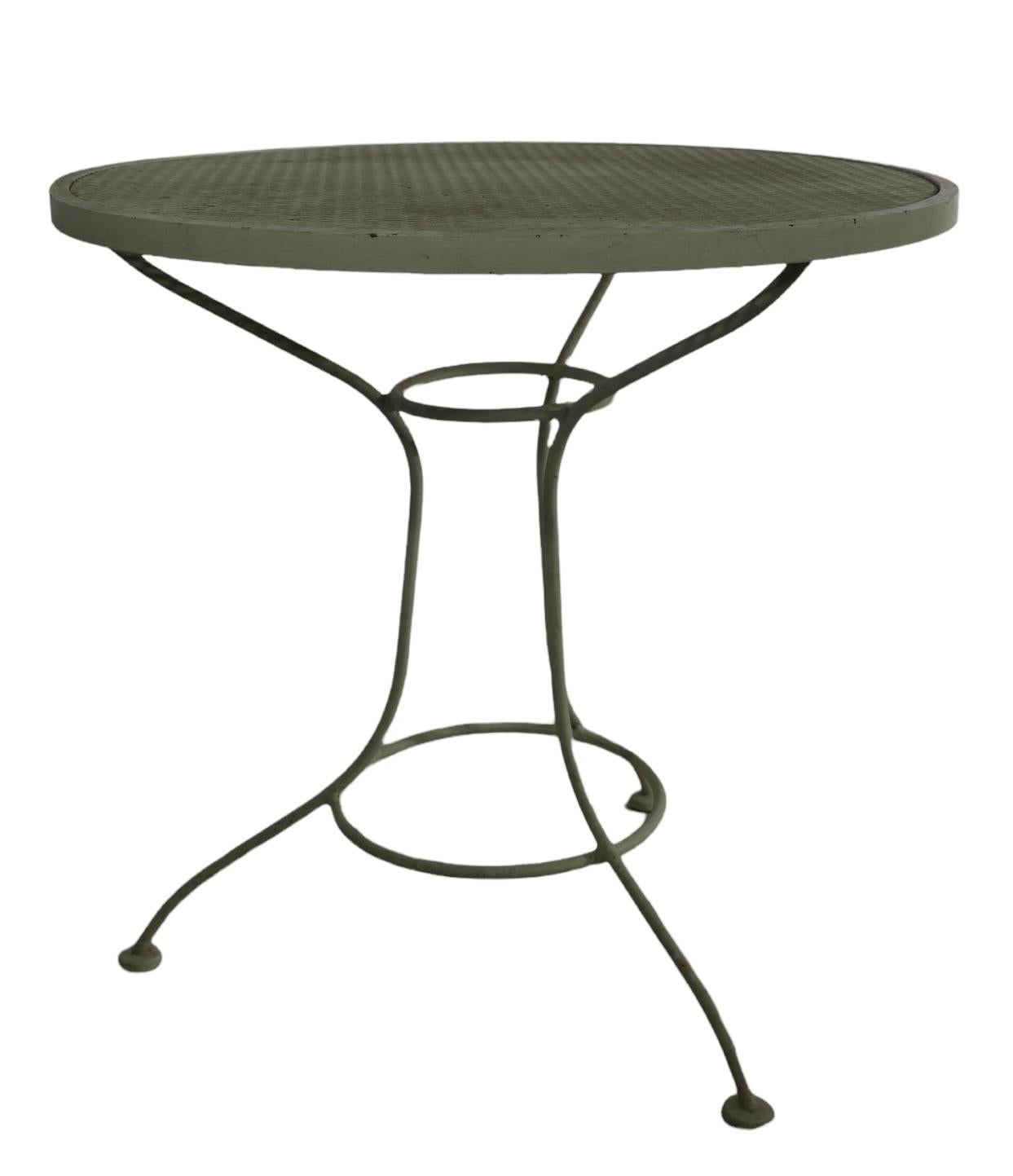 Chic and stylish diminutive cafe, dining table by Salterini. Perfect garden, patio, poolside table, having a wrought iron base, and metal mesh top surface. This example is in very good, original, clean and ready to use condition. 
 