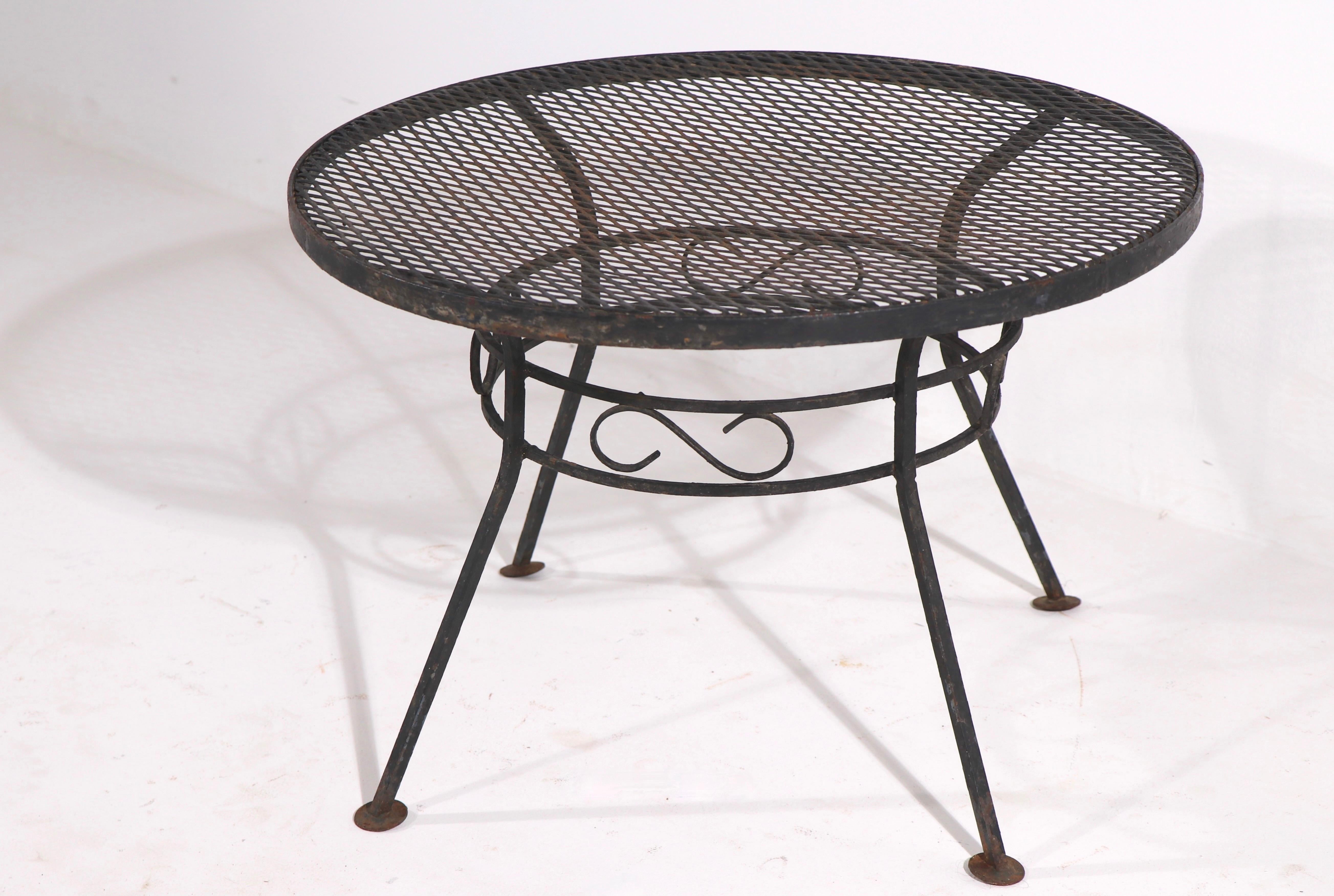 Diminutive side, occasional, poolside table attributed to Salterini. The table has a wrought iron frame, and a metal mesh top.
Clean original ready to use condition, no structural damage - black paint finish shows wear, normal and consistent with