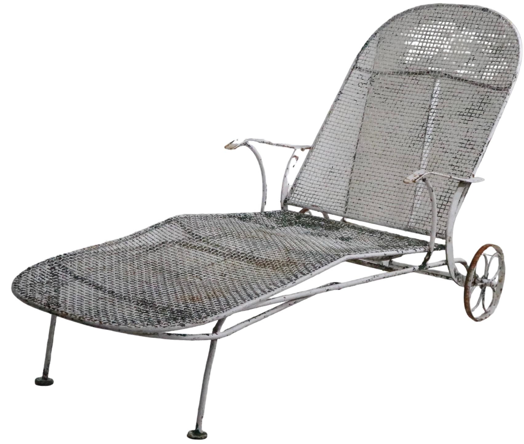 Stylish Mid Century wrought iron and metal mesh adjustable chaise lounge by Woodard Furniture. The chaise was designed as part of the highly sought after Sculptura Line, circa 1950. The lounge features  an adjustable back rest, which has four